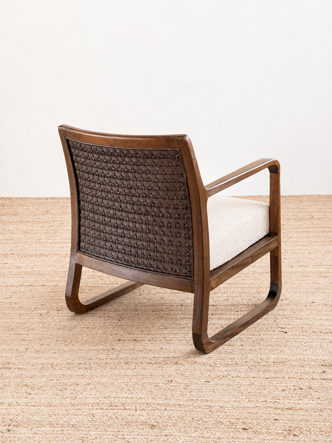 Wooden armchair with woven backrest on a beige carpet