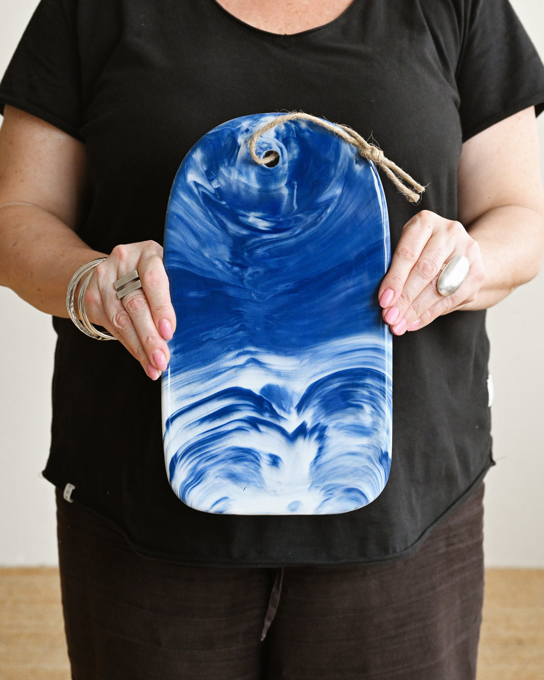 Person holding a blue and white marbled bag against a plain background