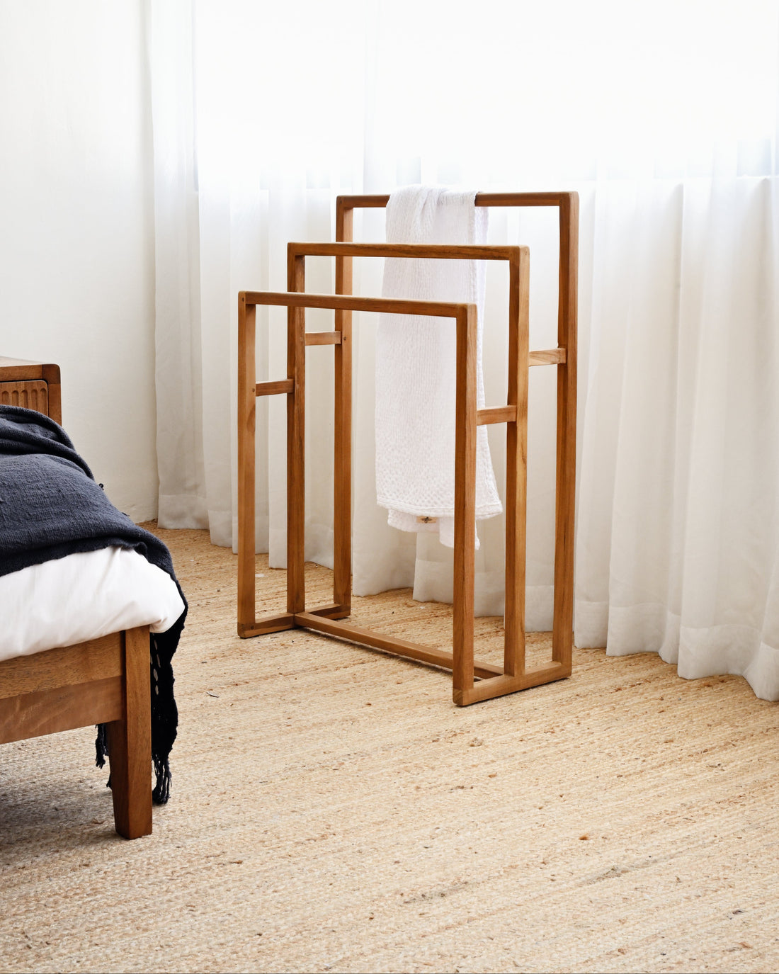 Wooden mirrors on a carpeted floor with white curtains in the background