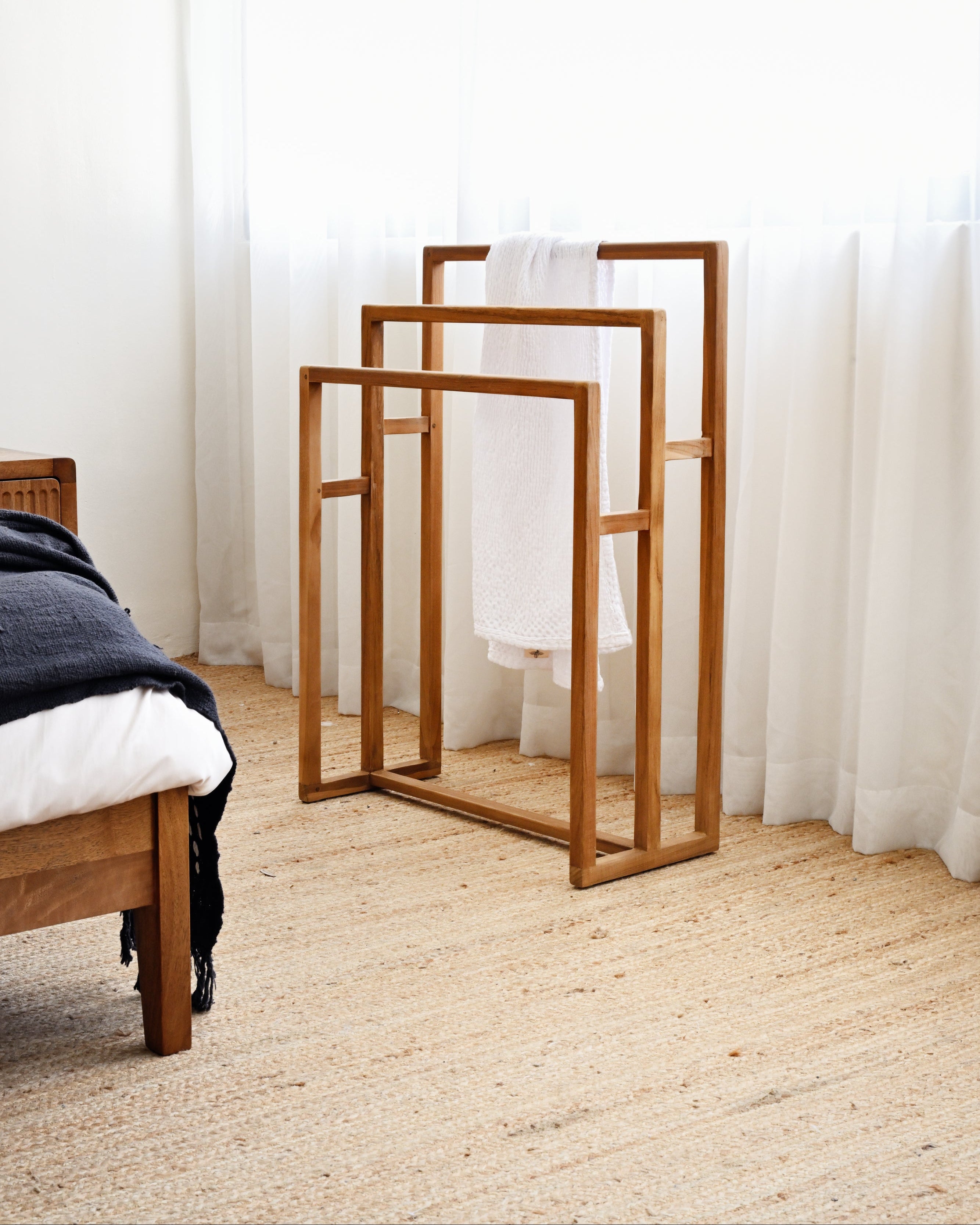 Wooden mirrors on a carpeted floor with white curtains in the background