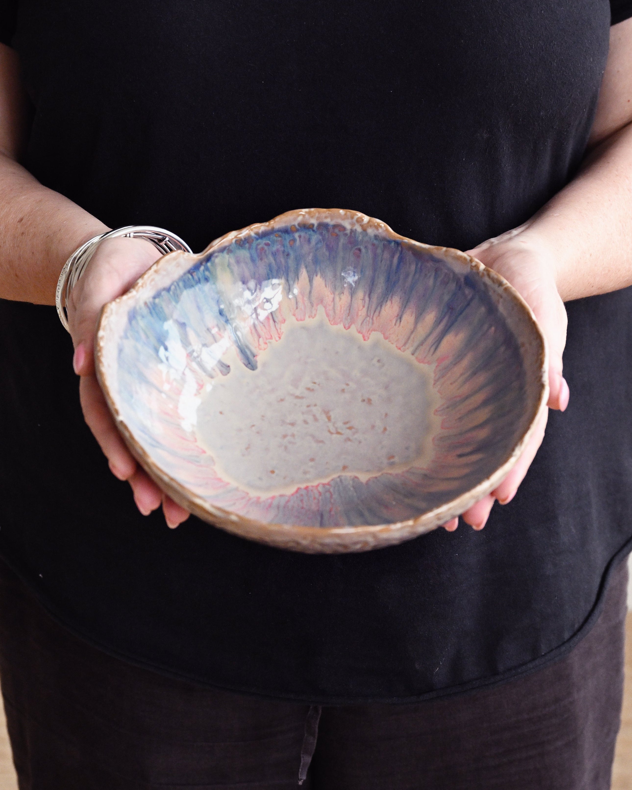 Person holding a ceramic bowl with a textured surface