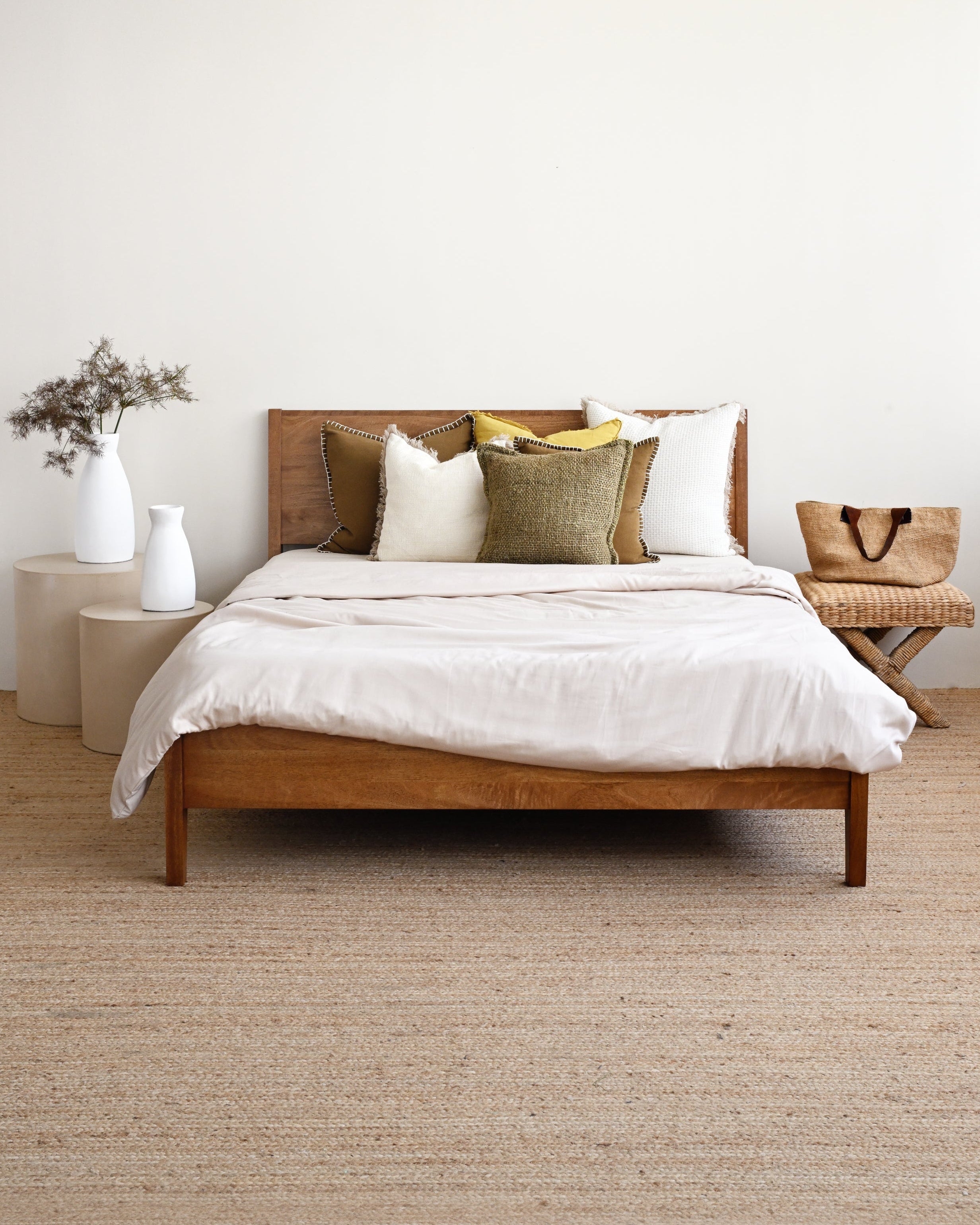 Wooden bed with white bedding in a minimalistic room