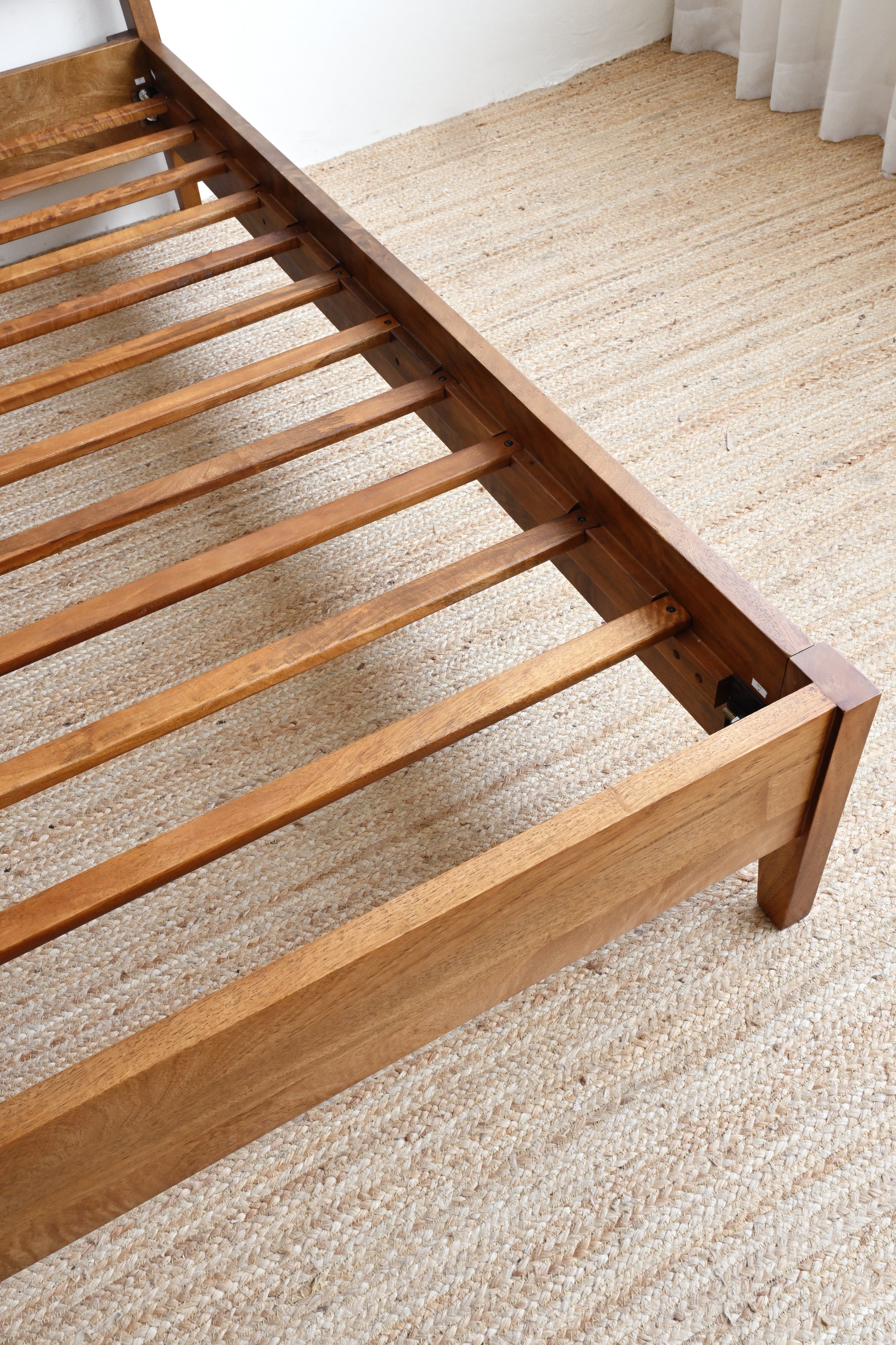 Wooden bed frame on a carpeted floor