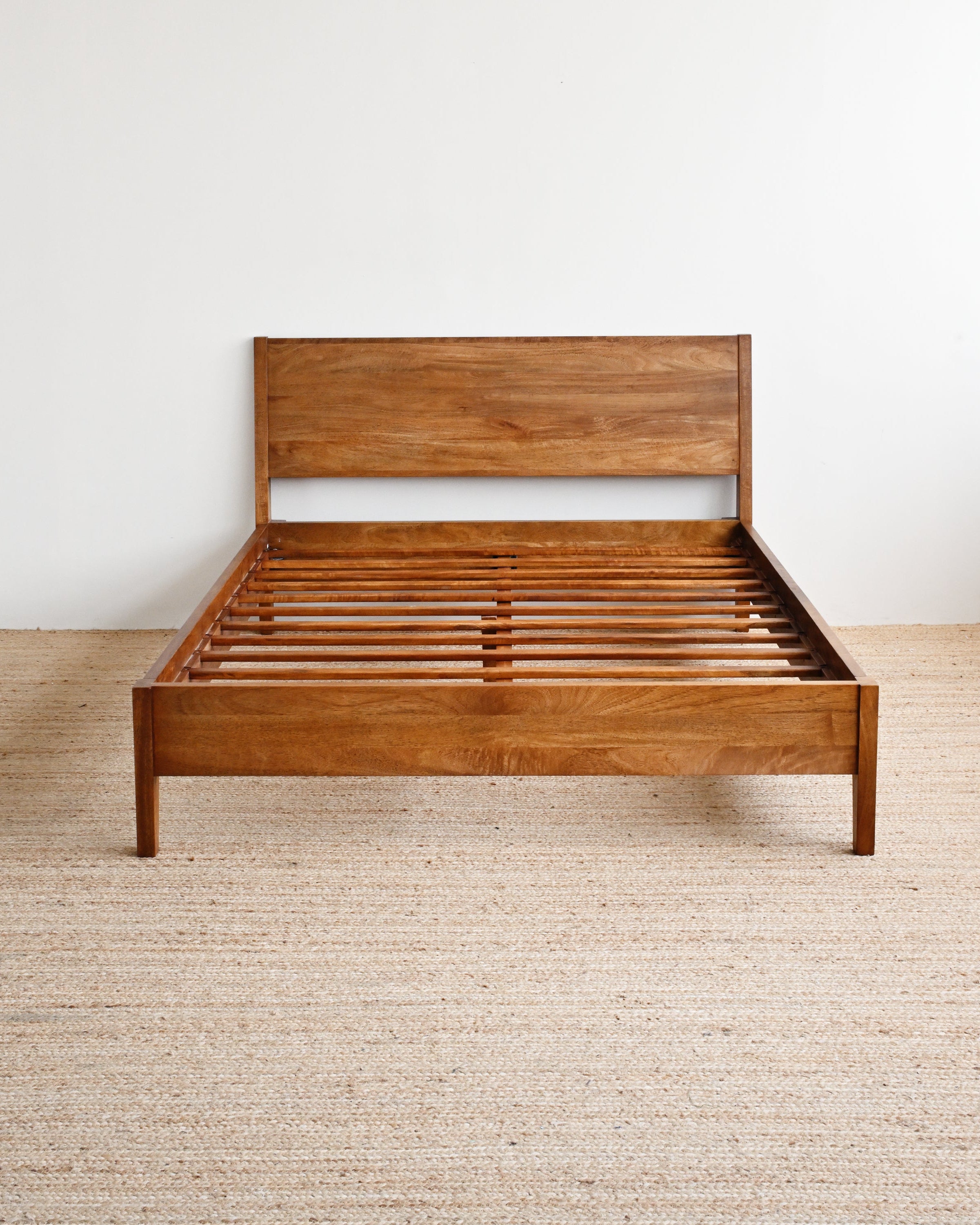 Wooden bed frame on a plain background