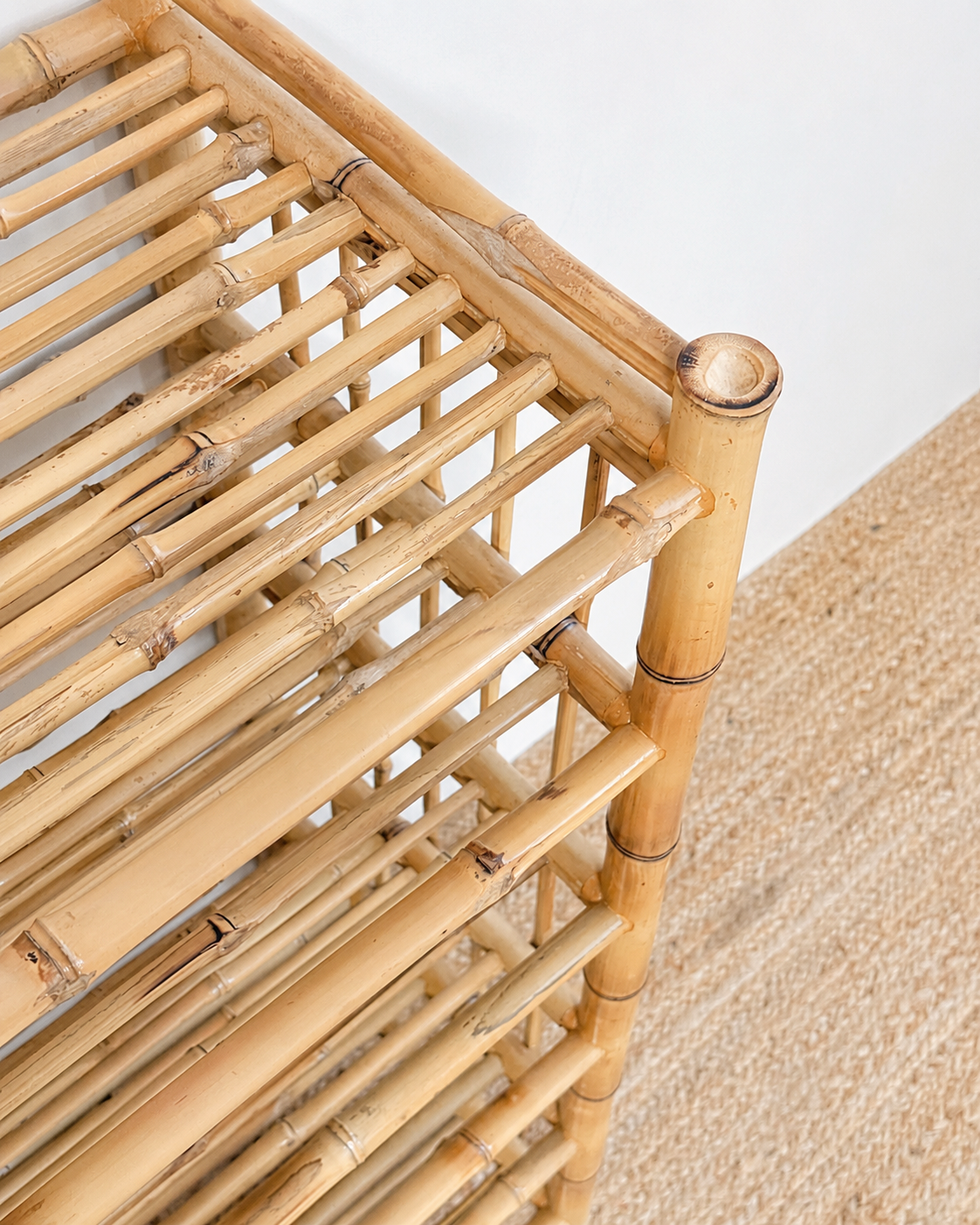 Close-up of a bamboo shelf with a textured beige carpet in the background
