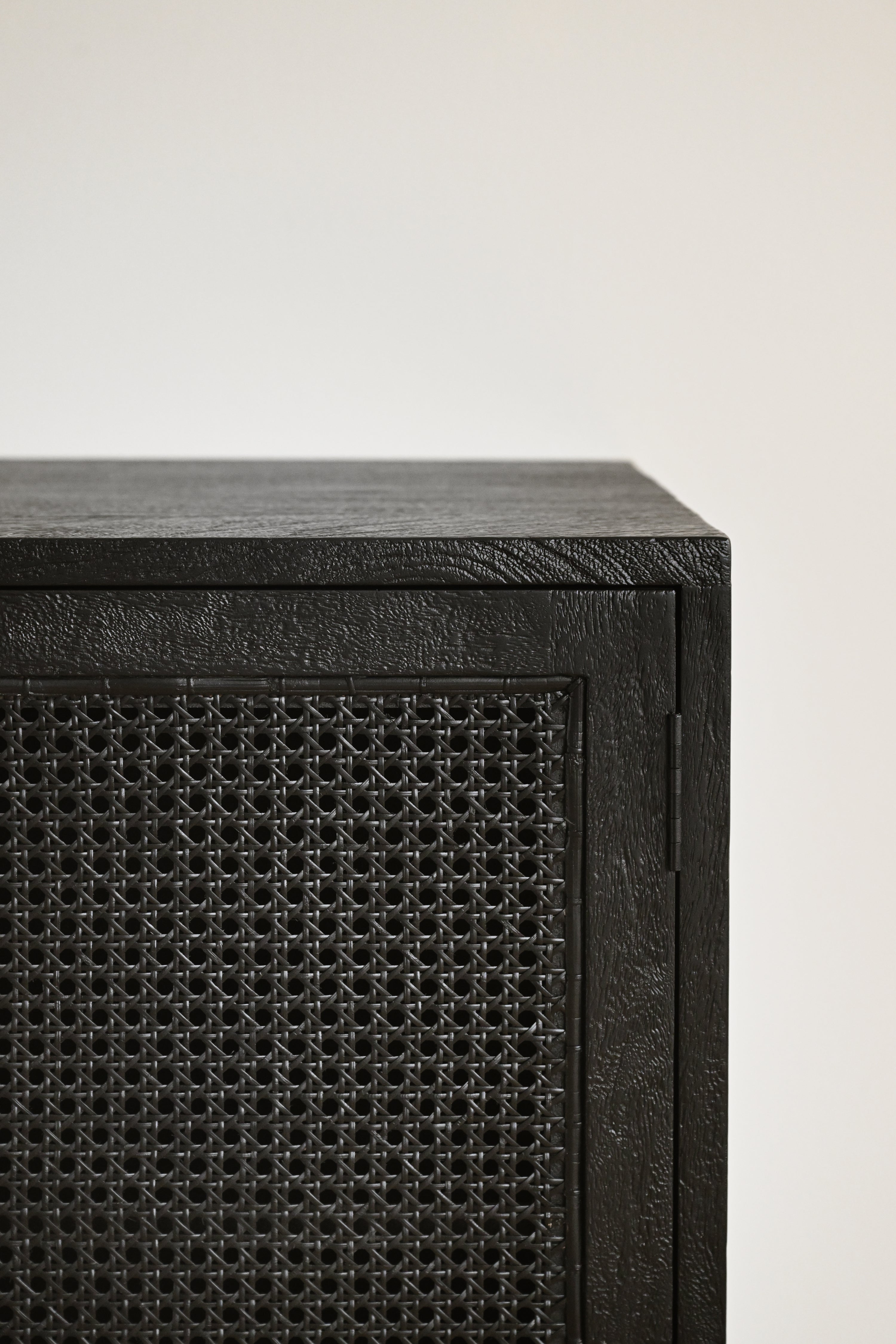 Black speaker with woven pattern on a white background