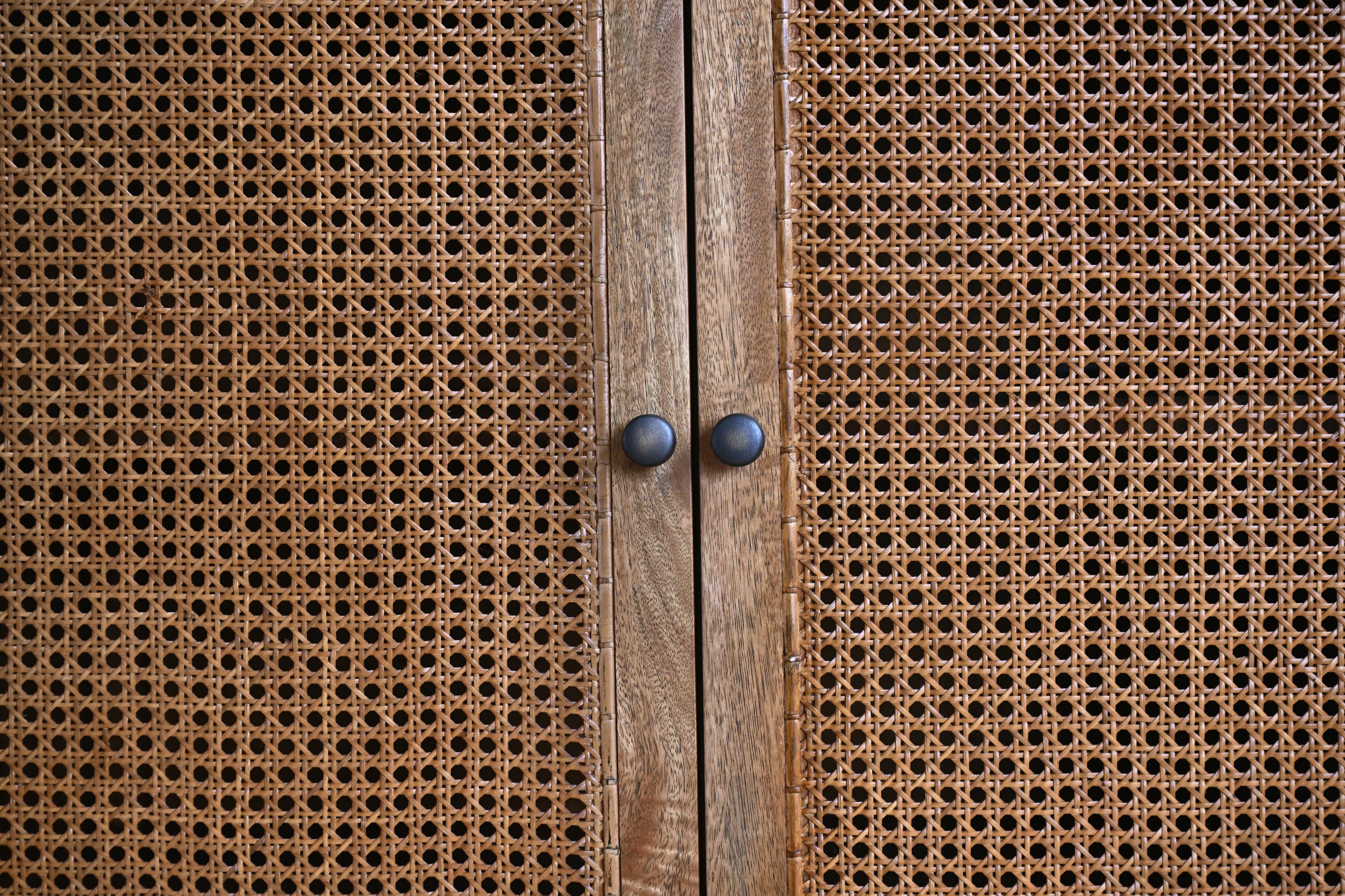 Close-up of a wooden cabinet with rattan doors.