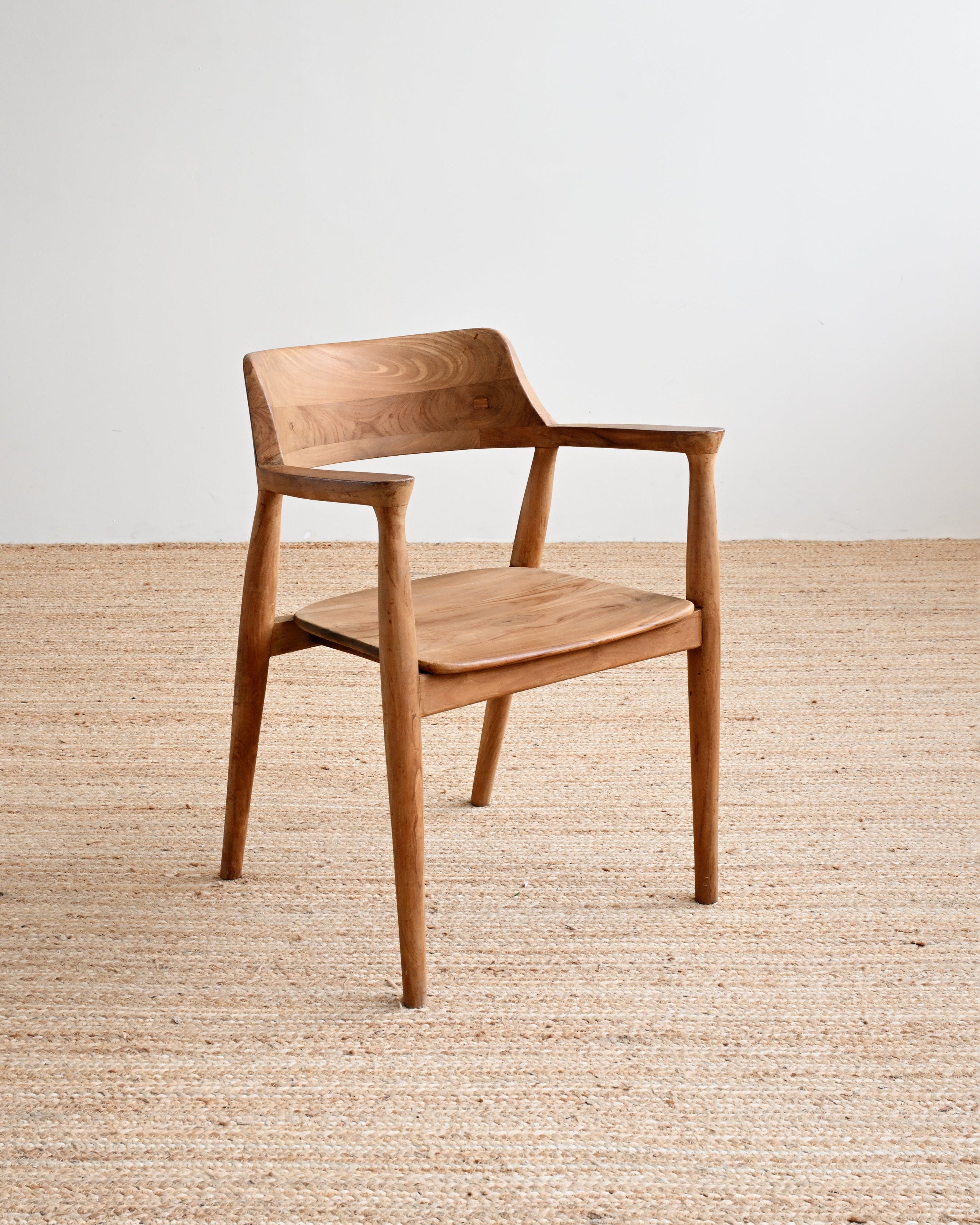 Wooden chair on a wooden floor with a white wall background