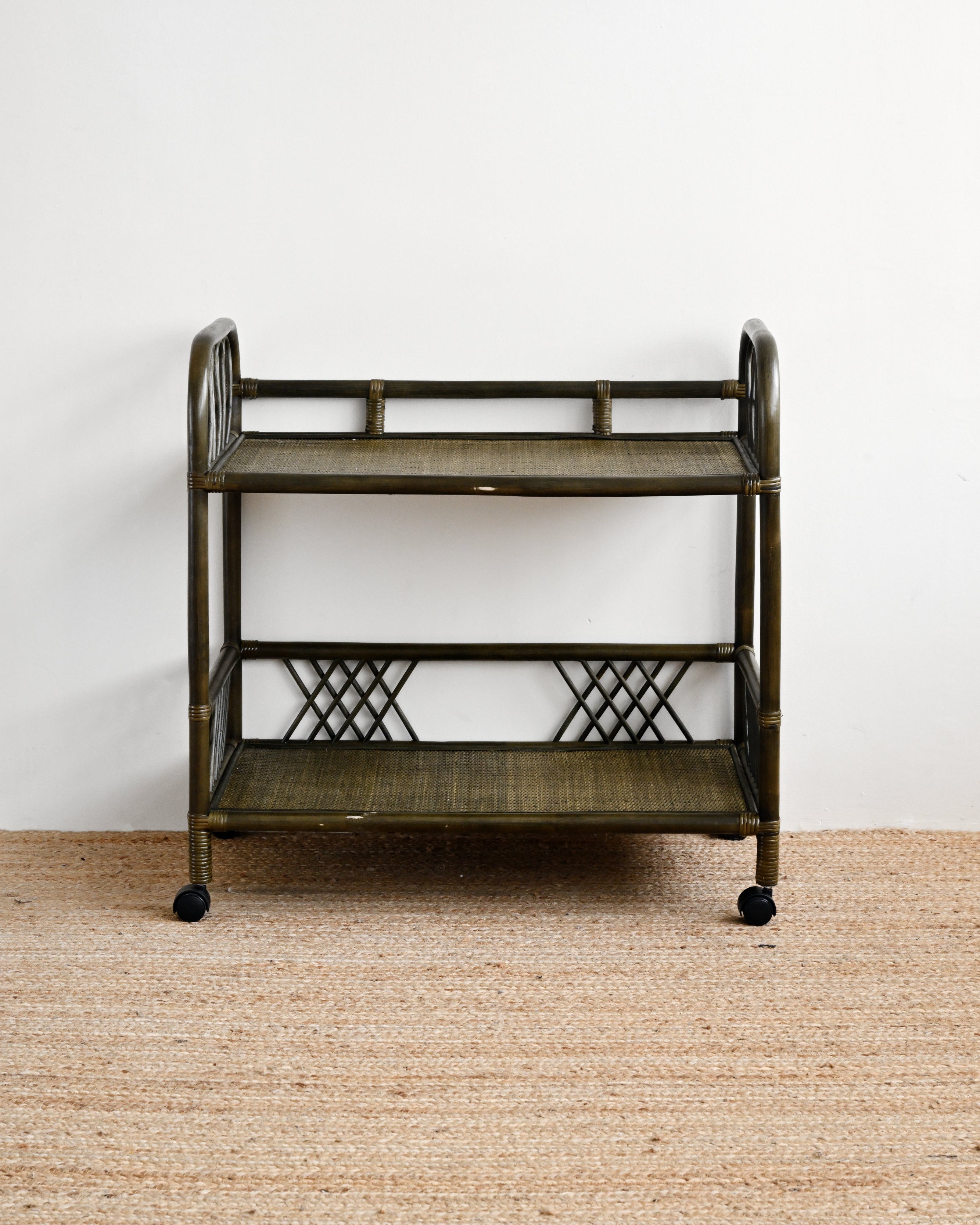 Vintage-style metal serving cart on a beige carpet with a white wall background
