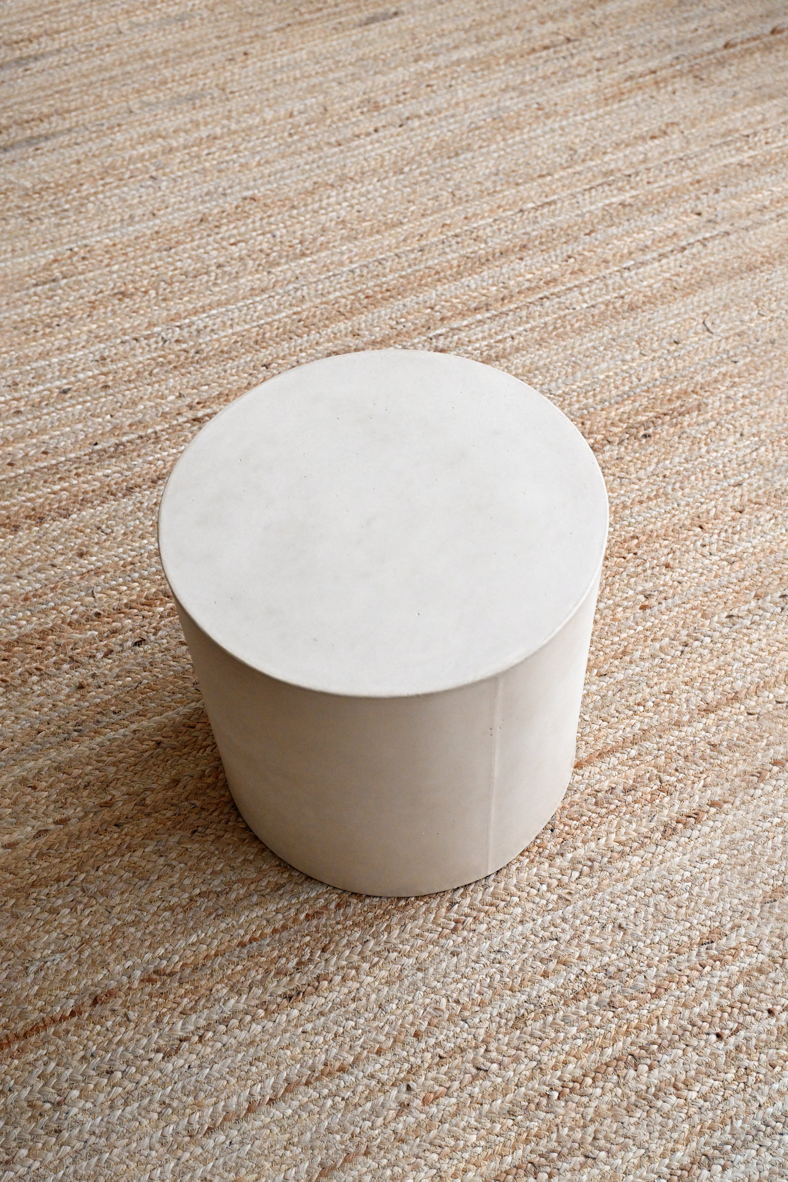 White cylindrical object on a textured beige surface