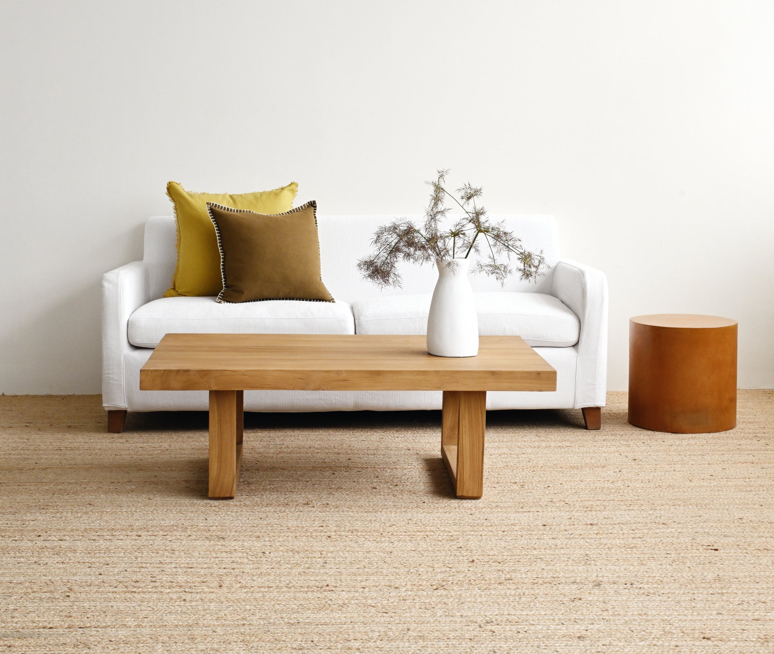 Modern living room with a white sofa, wooden coffee table, and decorative elements.
