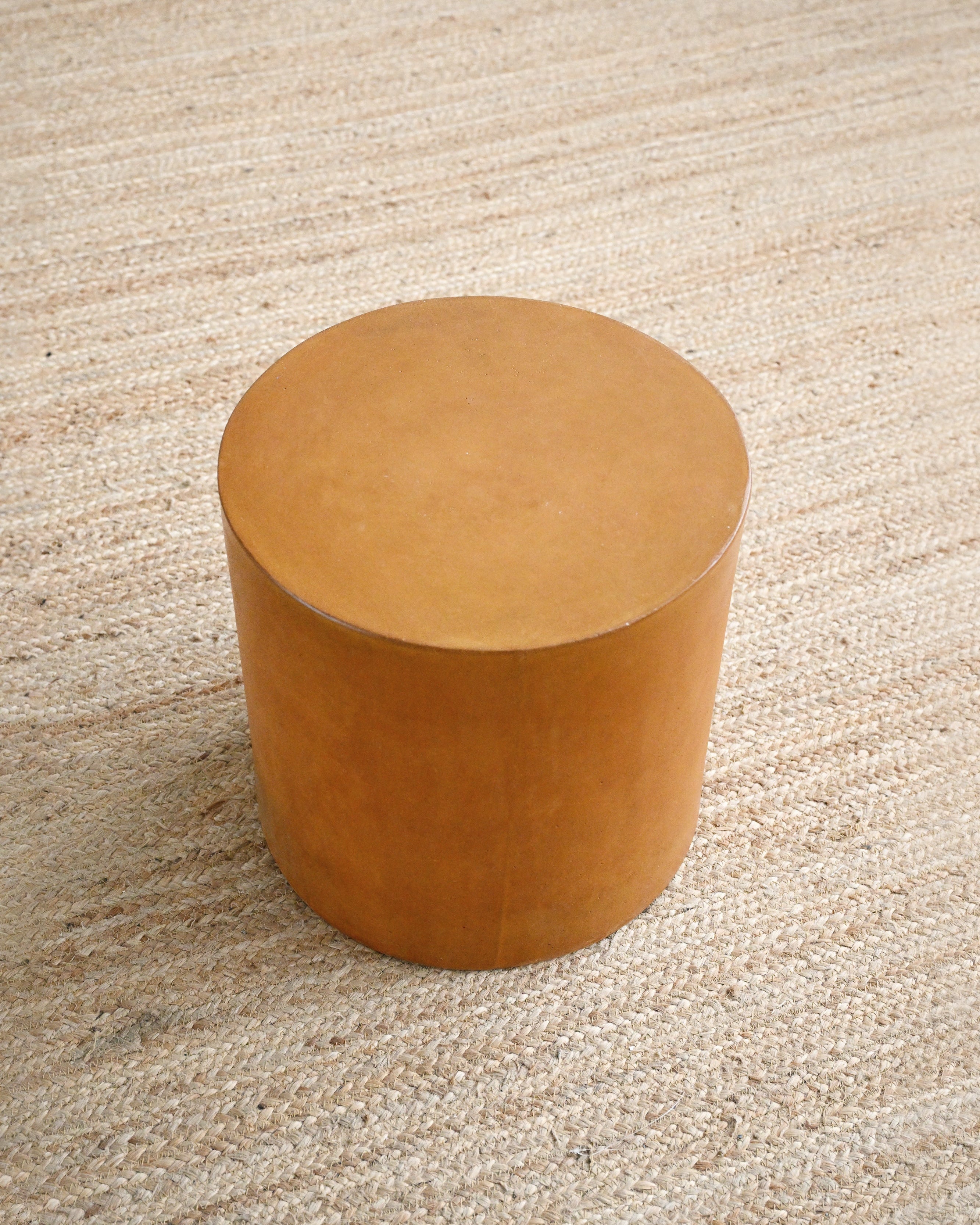 Round brown stool on a beige carpet