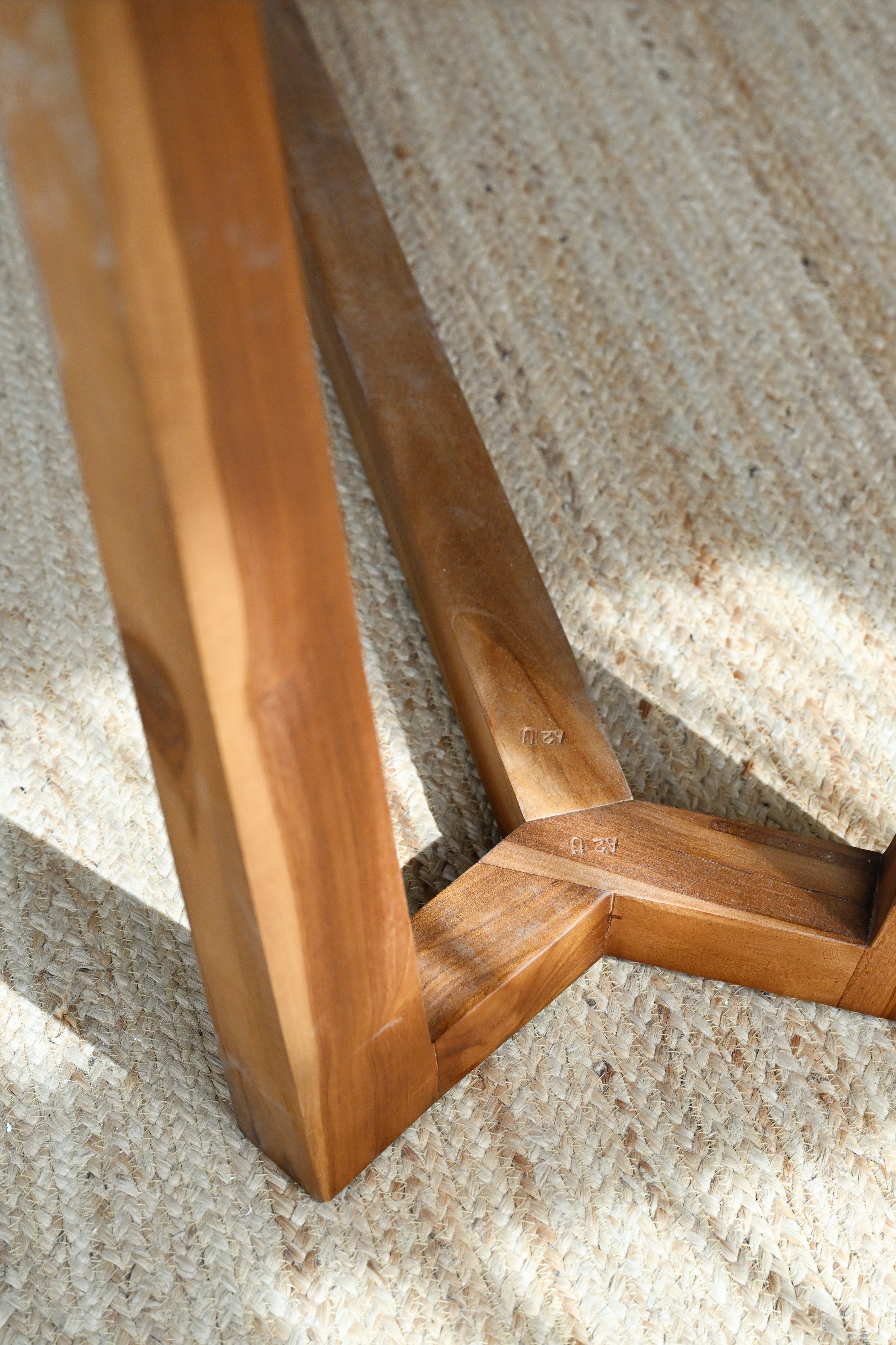 Close-up of a wooden chair leg on a textured surface