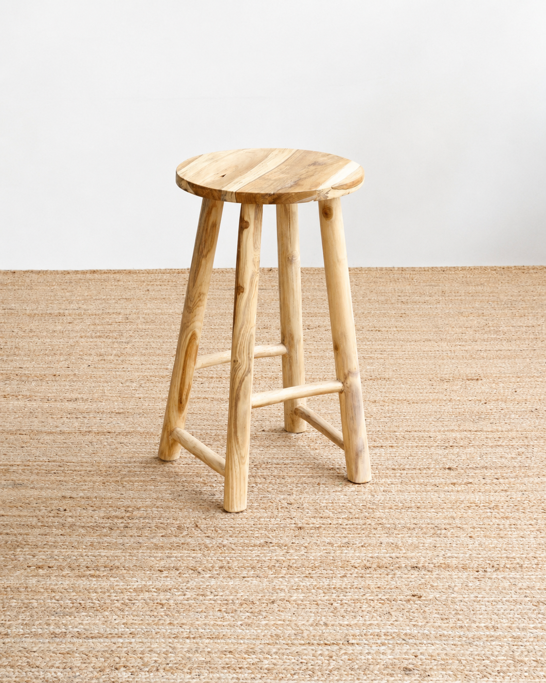 Wooden stool on a textured beige floor with a light gray wall background