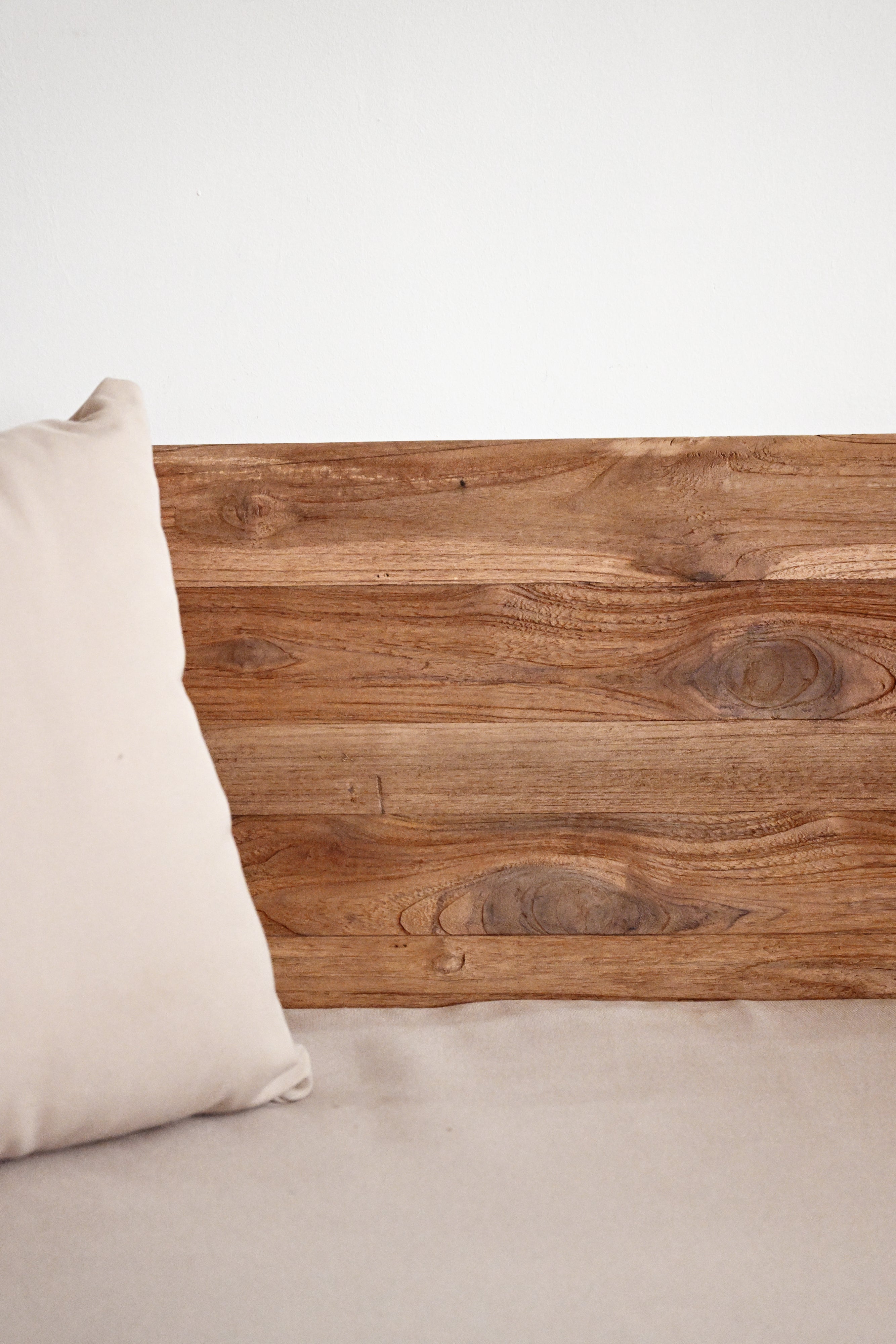 Wooden headboard with a pillow on a neutral background