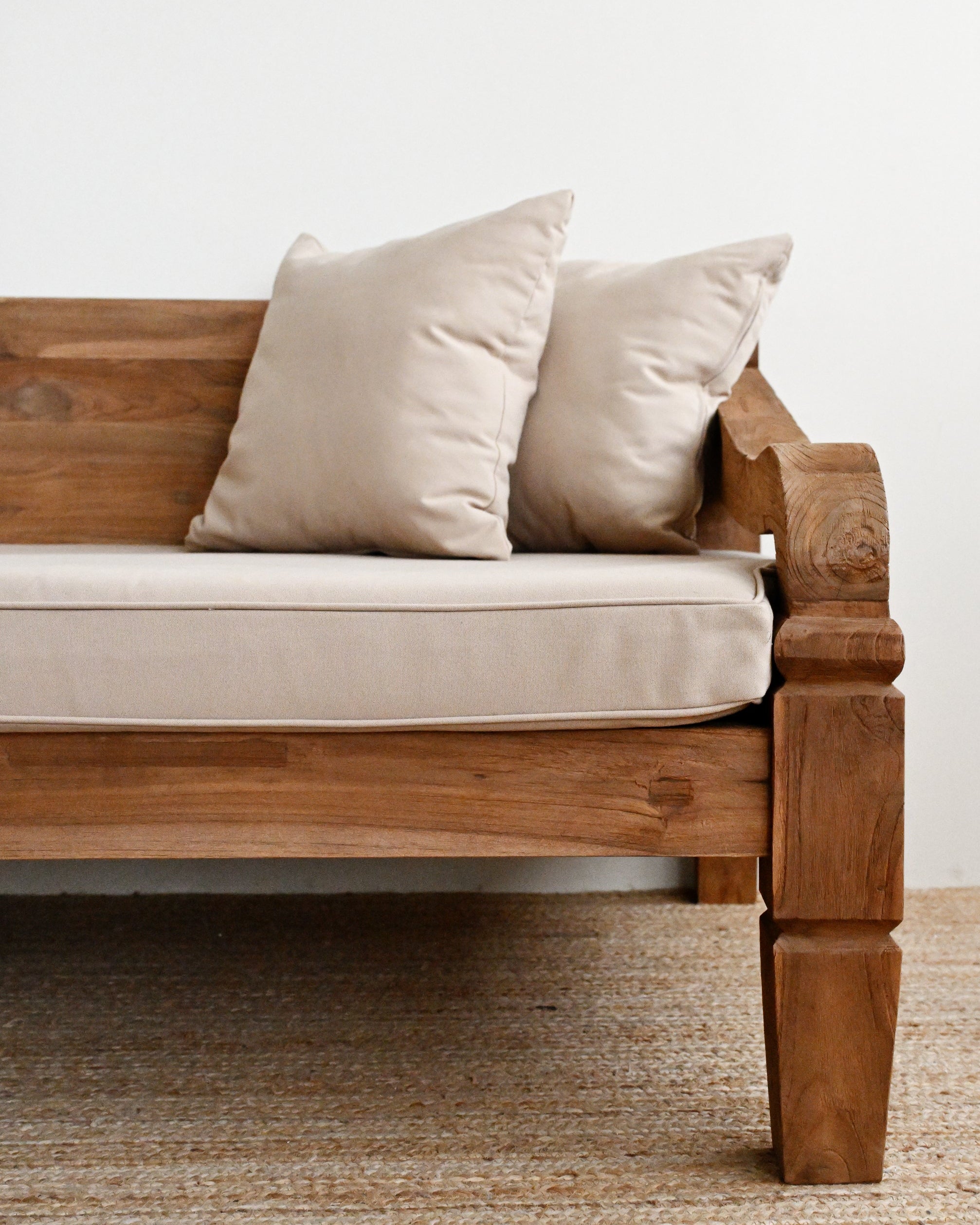 Wooden sofa with beige cushions on a neutral background