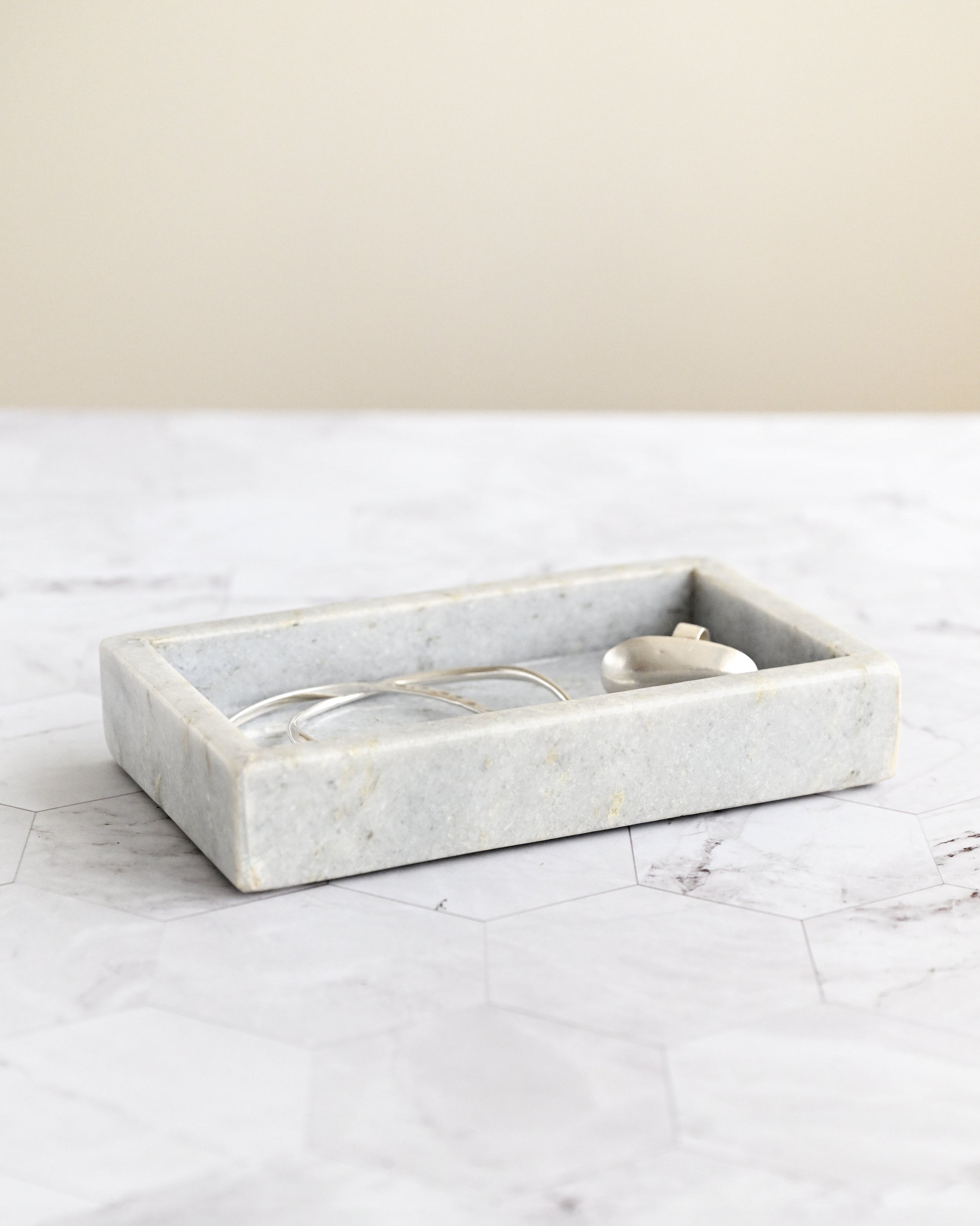 Marble tray on a marble surface with a neutral background