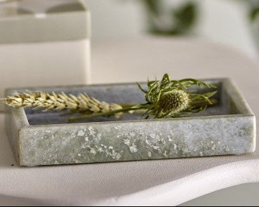 Decorative stone tray with greenery on a light surface