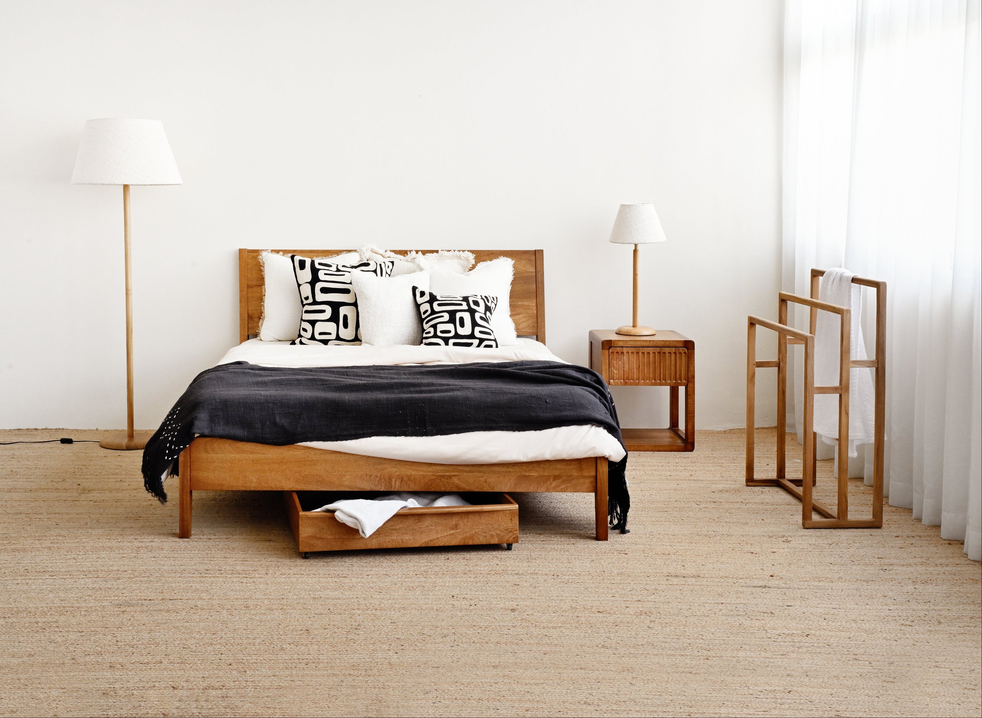 Modern bedroom with wooden bed, nightstands, and lamps.