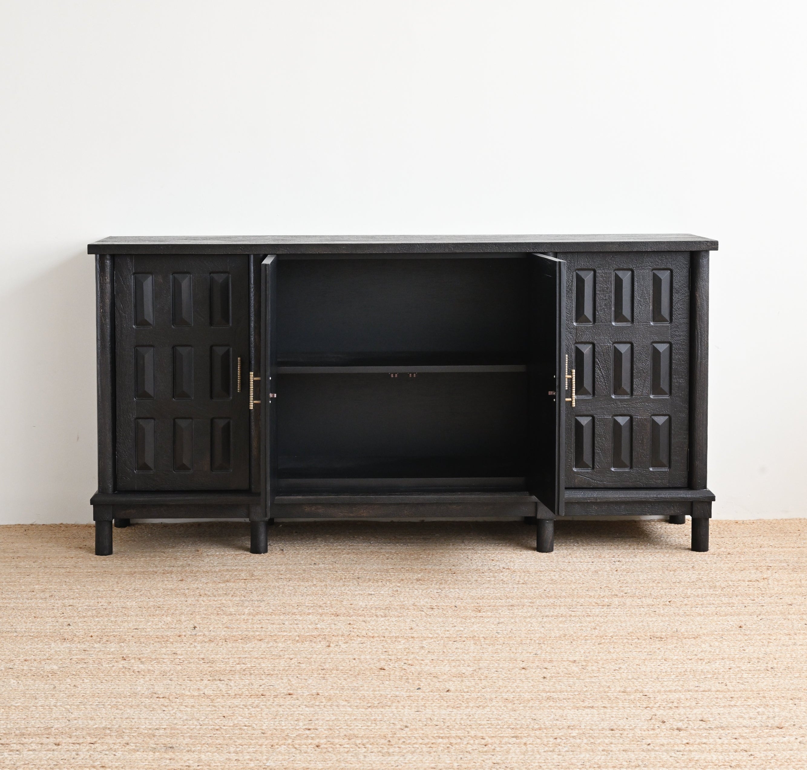 Black cabinet with open doors on a beige carpet against a white wall