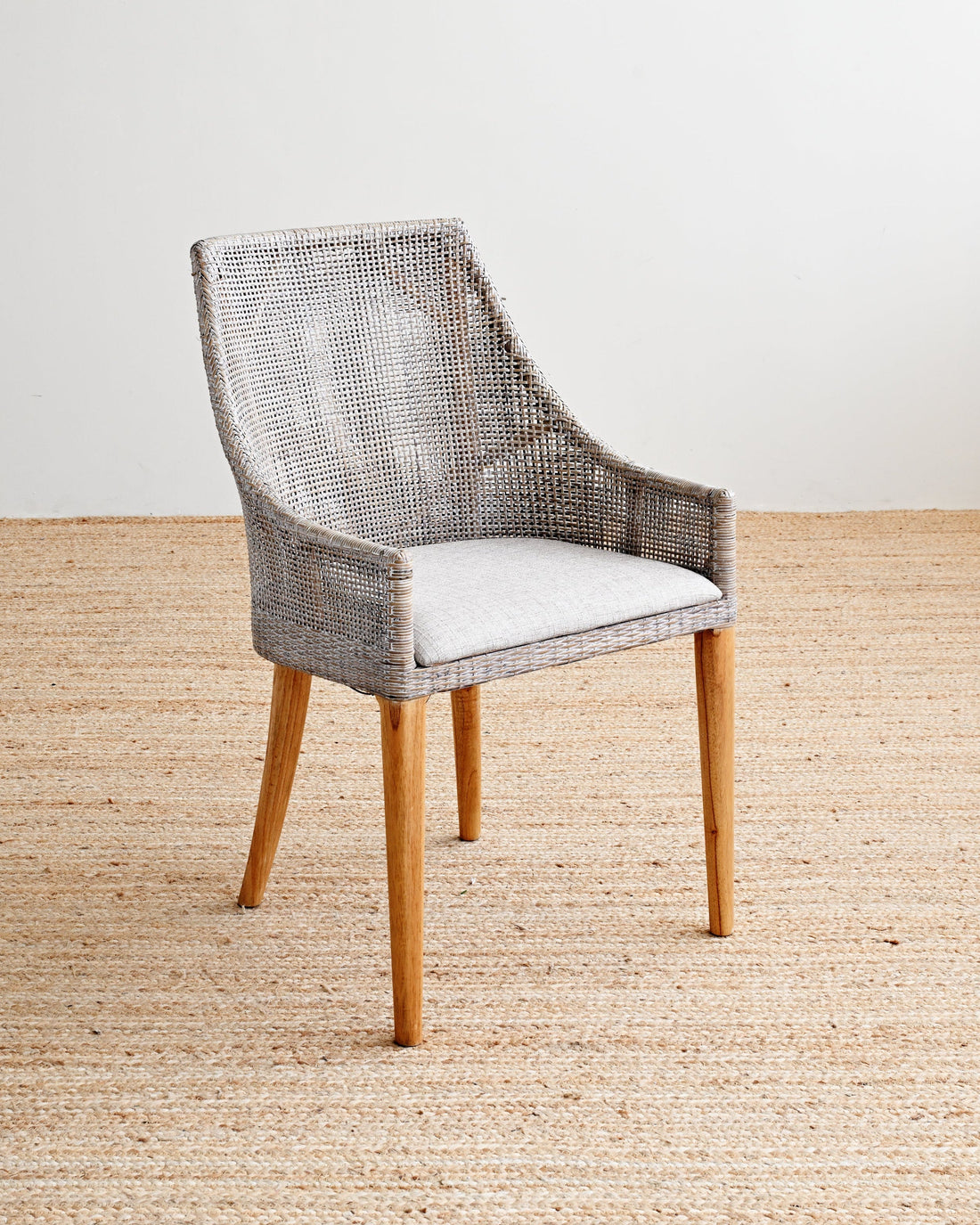 Chair with woven backrest and wooden legs on a beige carpet