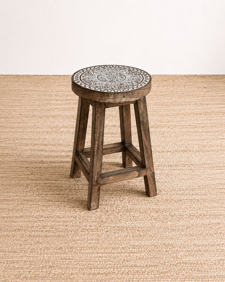 Wooden stool with a patterned top on a beige carpet
