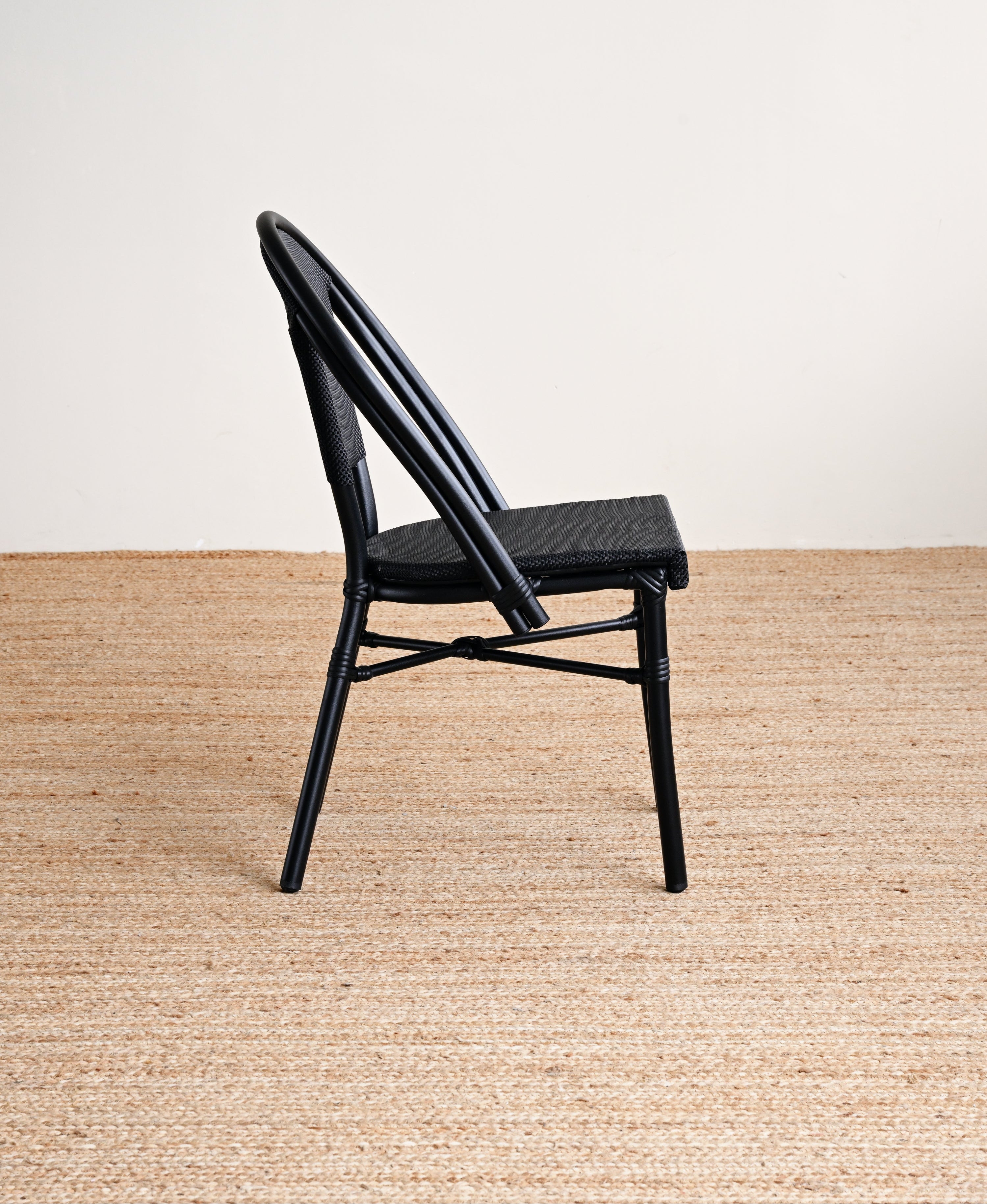 Black chair on a beige carpet with a white wall background
