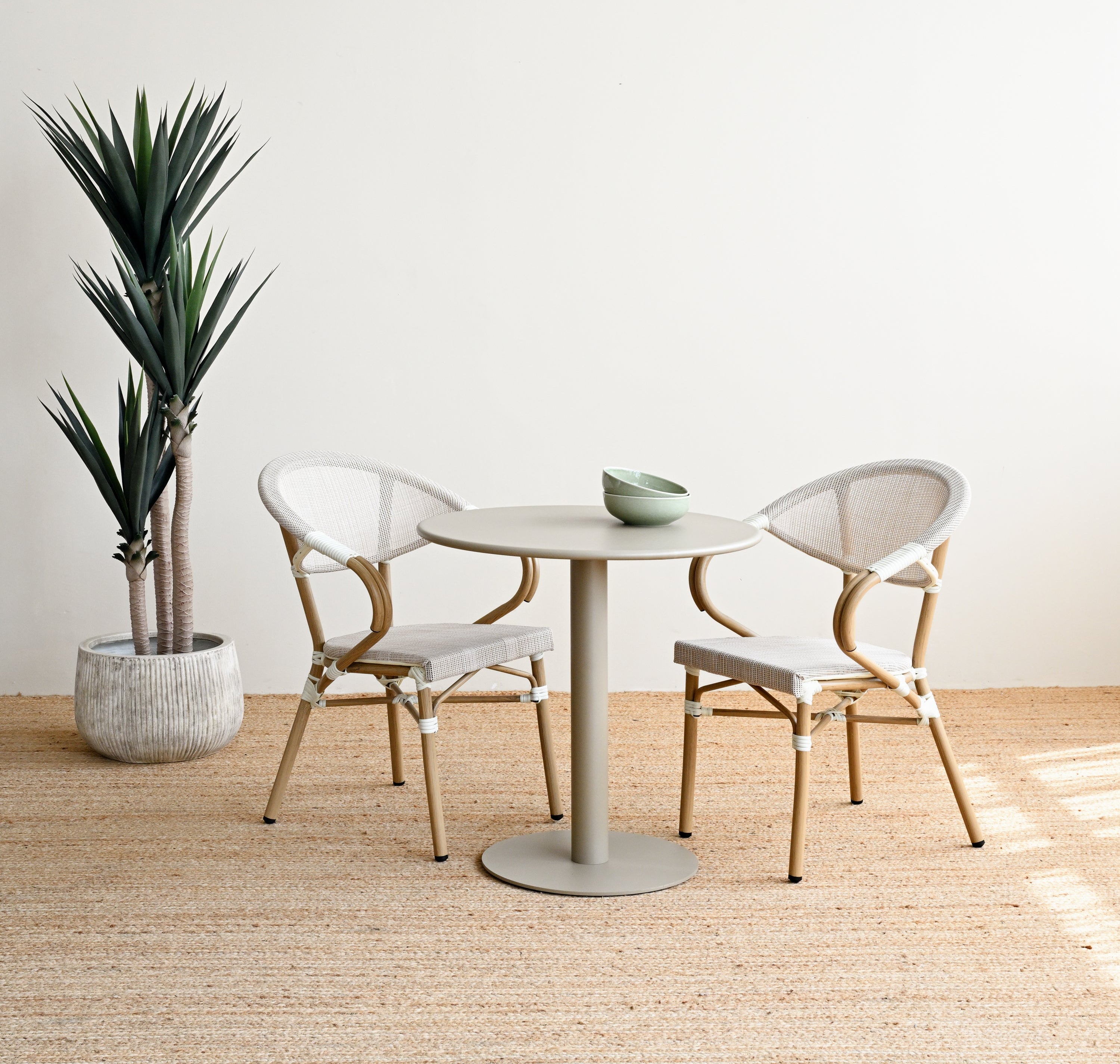 Modern dining area with a round table and chairs in a minimalistic setting.