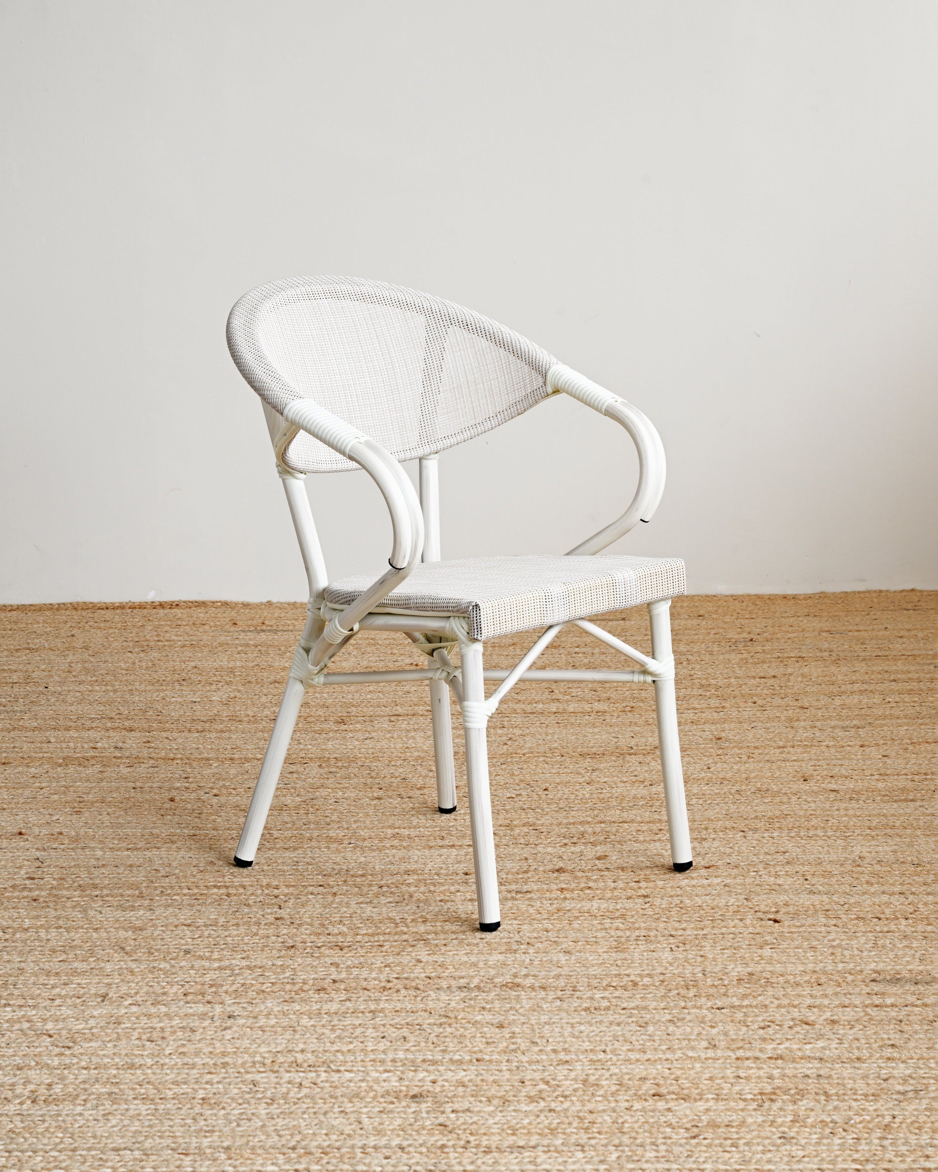 White chair on a textured beige floor with a plain white wall background