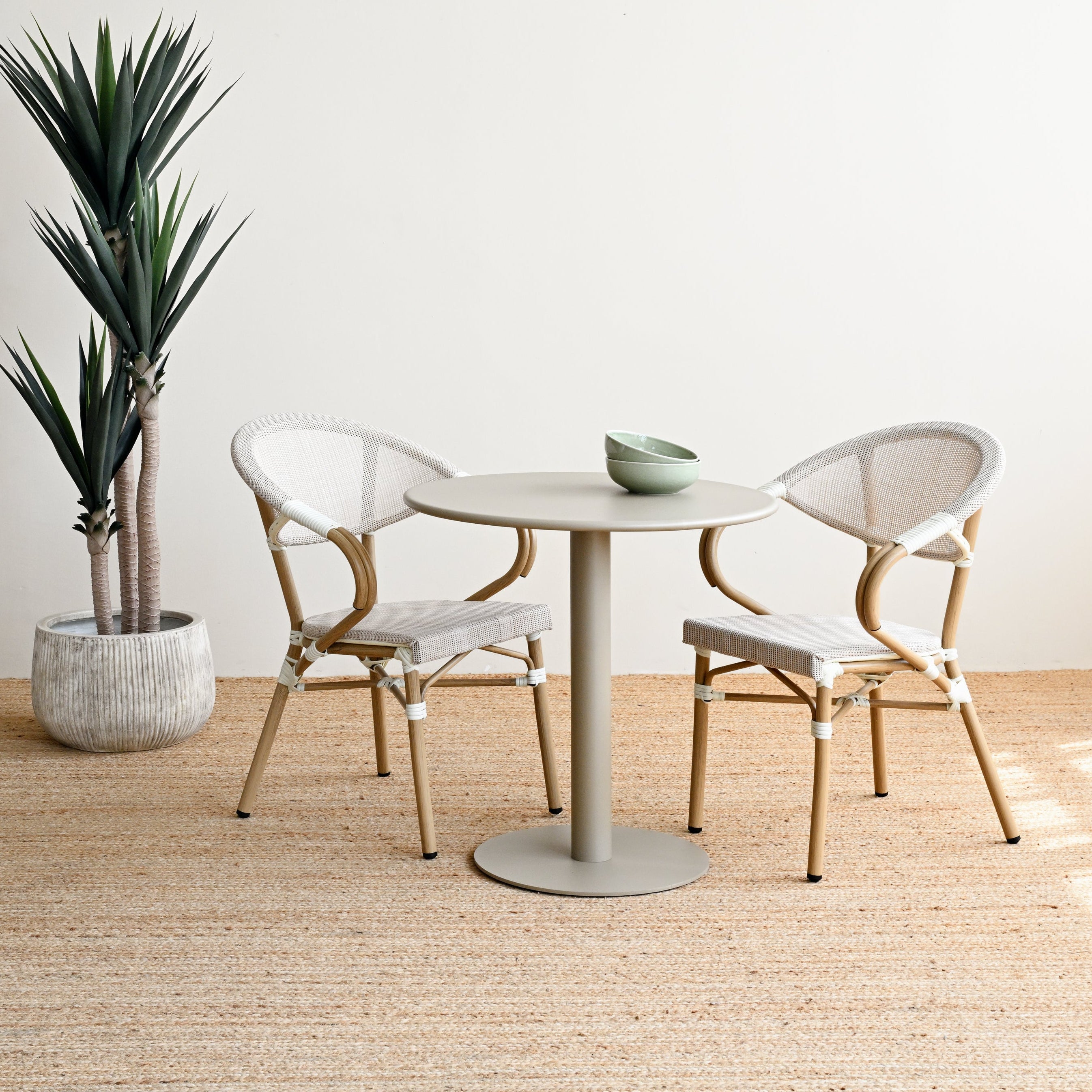 Modern dining area with a round table and chairs in a minimalistic setting.