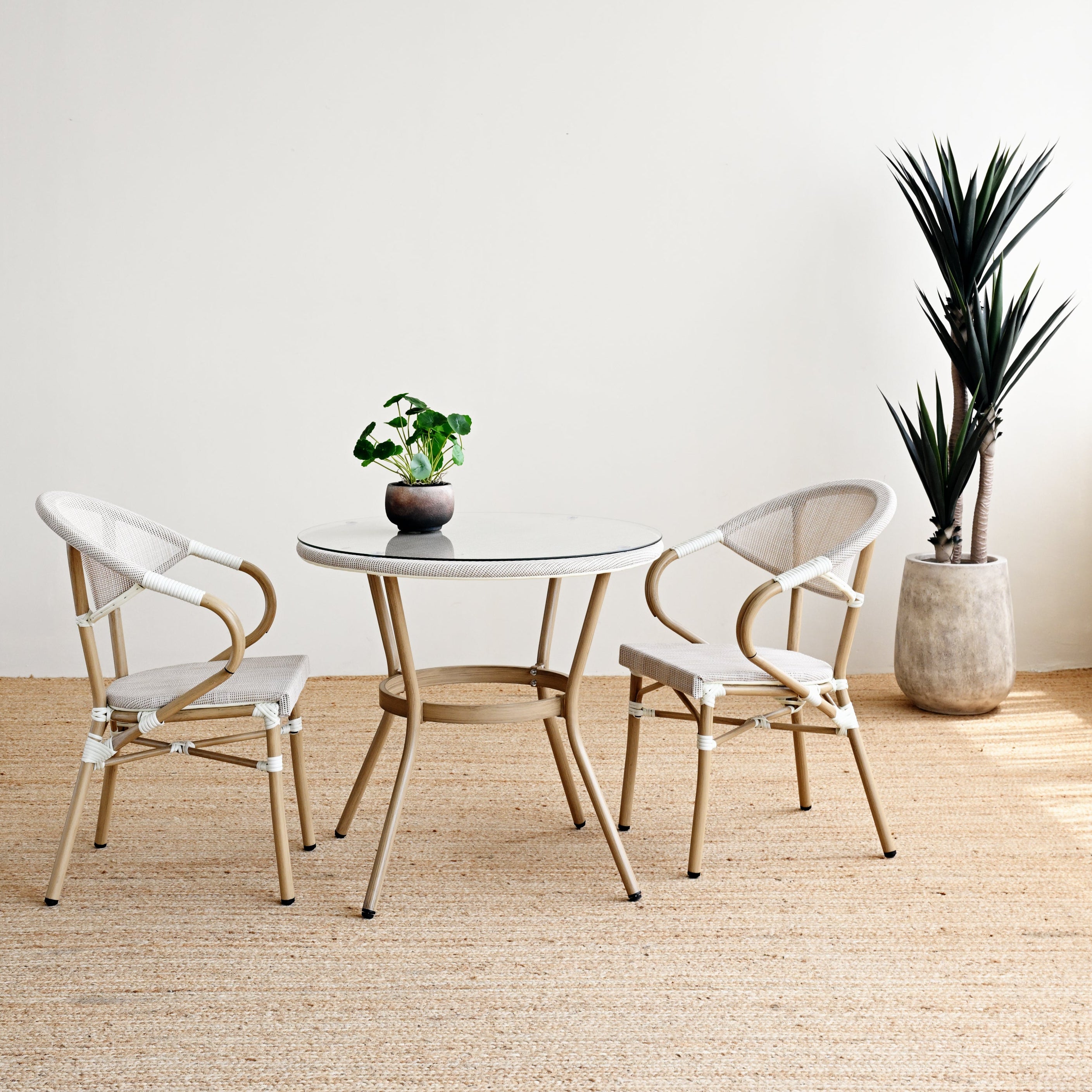 Modern dining set with round table and chairs in a minimalistic room.