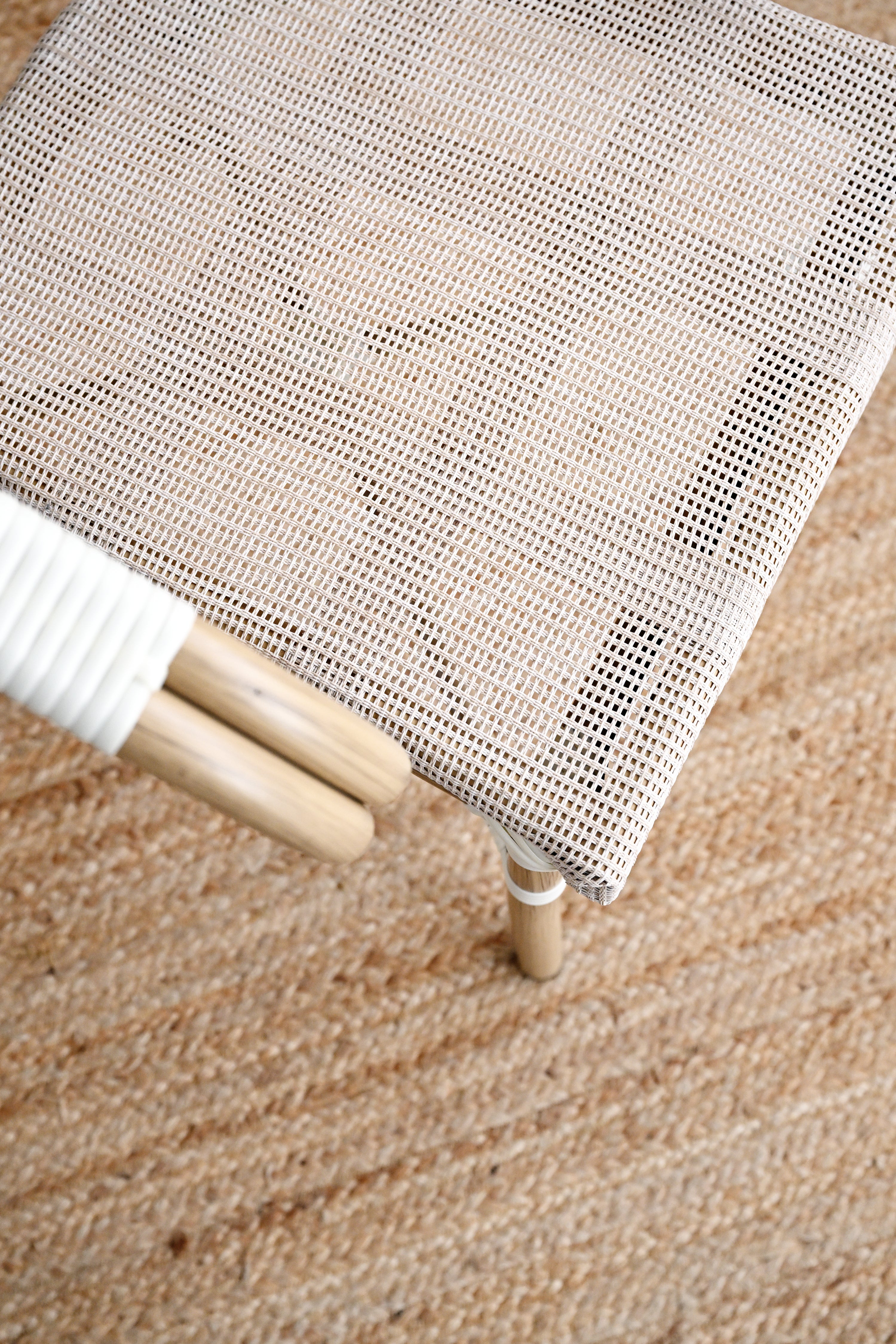 Close-up of a textured white screen or curtain on a wooden stool against a brown carpeted floor.