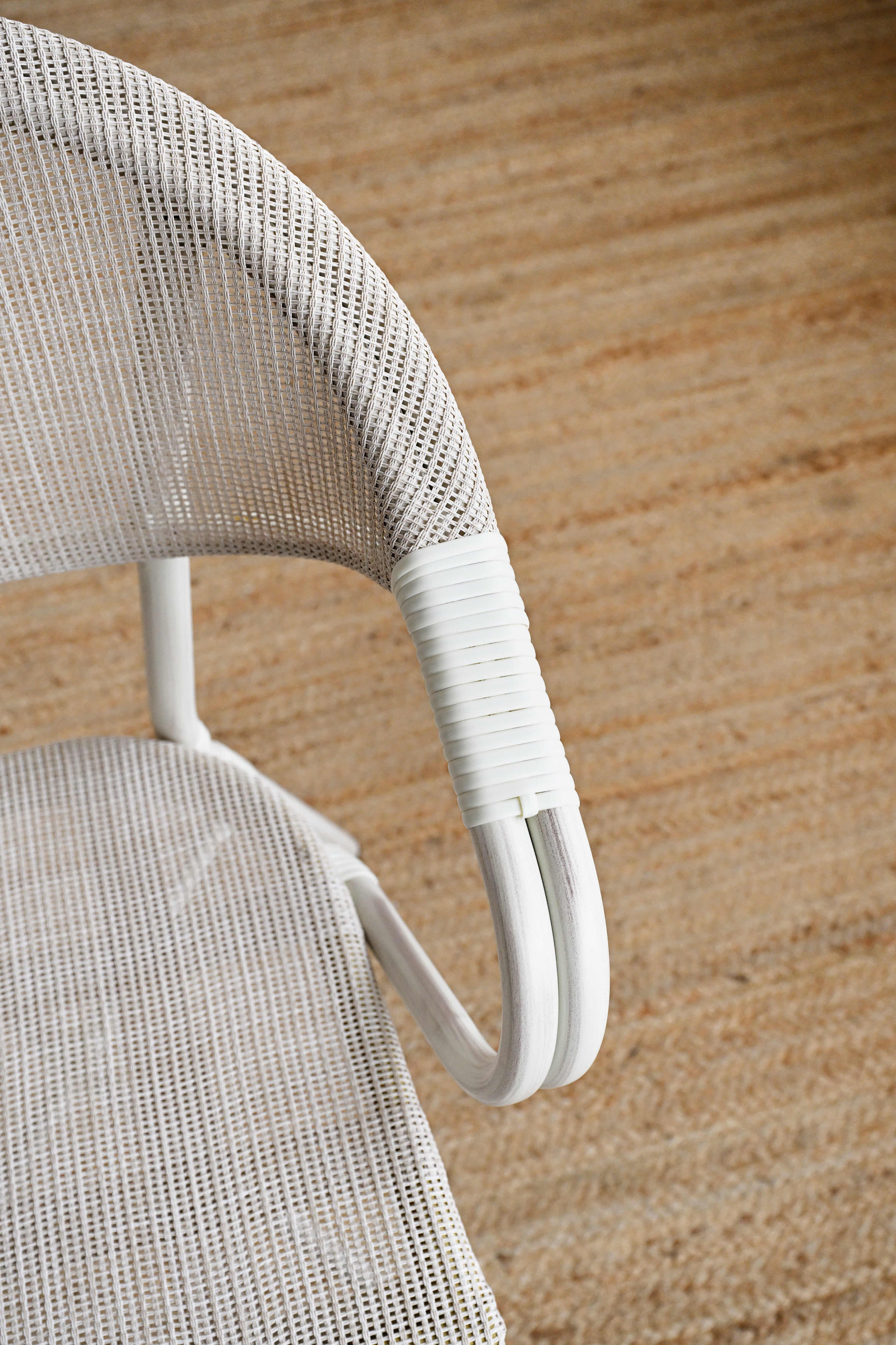 Close-up of a white wicker chair on a wooden floor