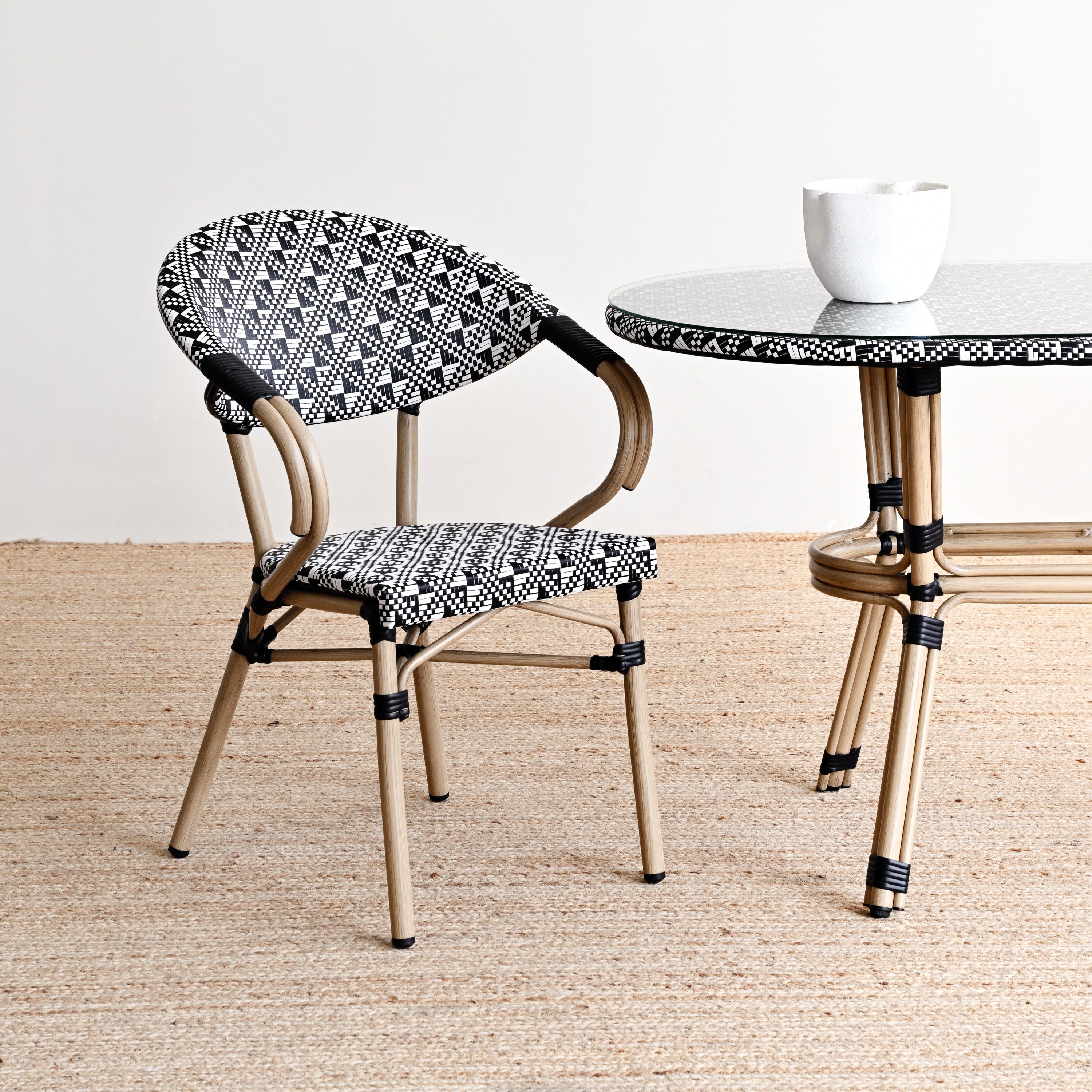 Chair and table with black and white patterned seats and legs on a beige floor.