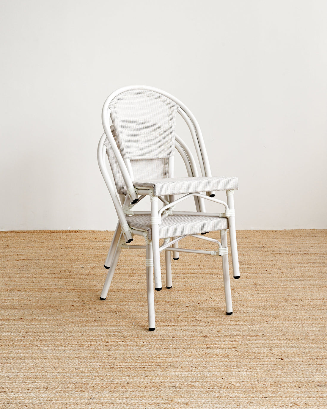 White chair on a beige carpet with a white wall background