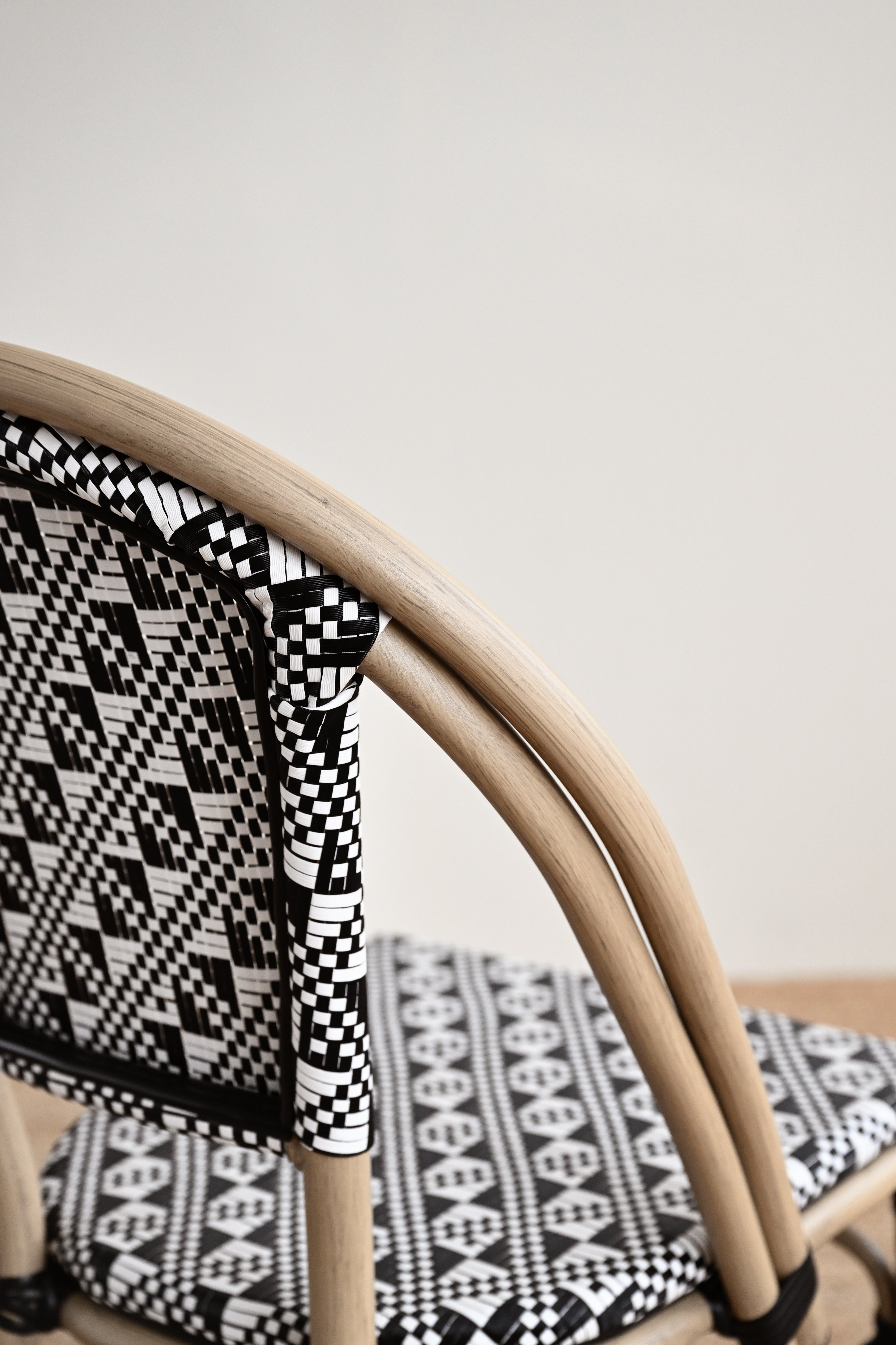 Chair with black and white patterned cushion on a plain background