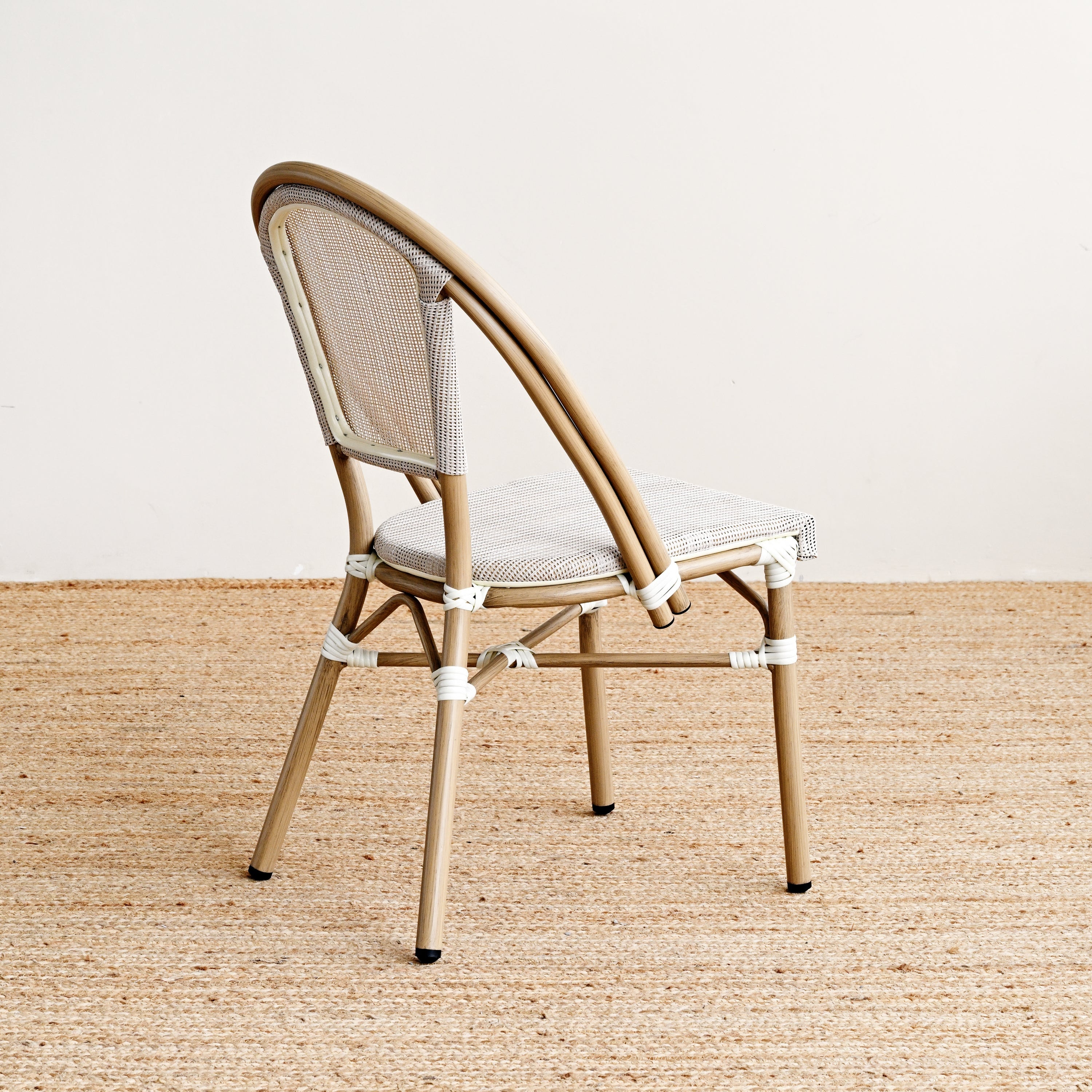 Beige chair with woven backrest on a beige carpet