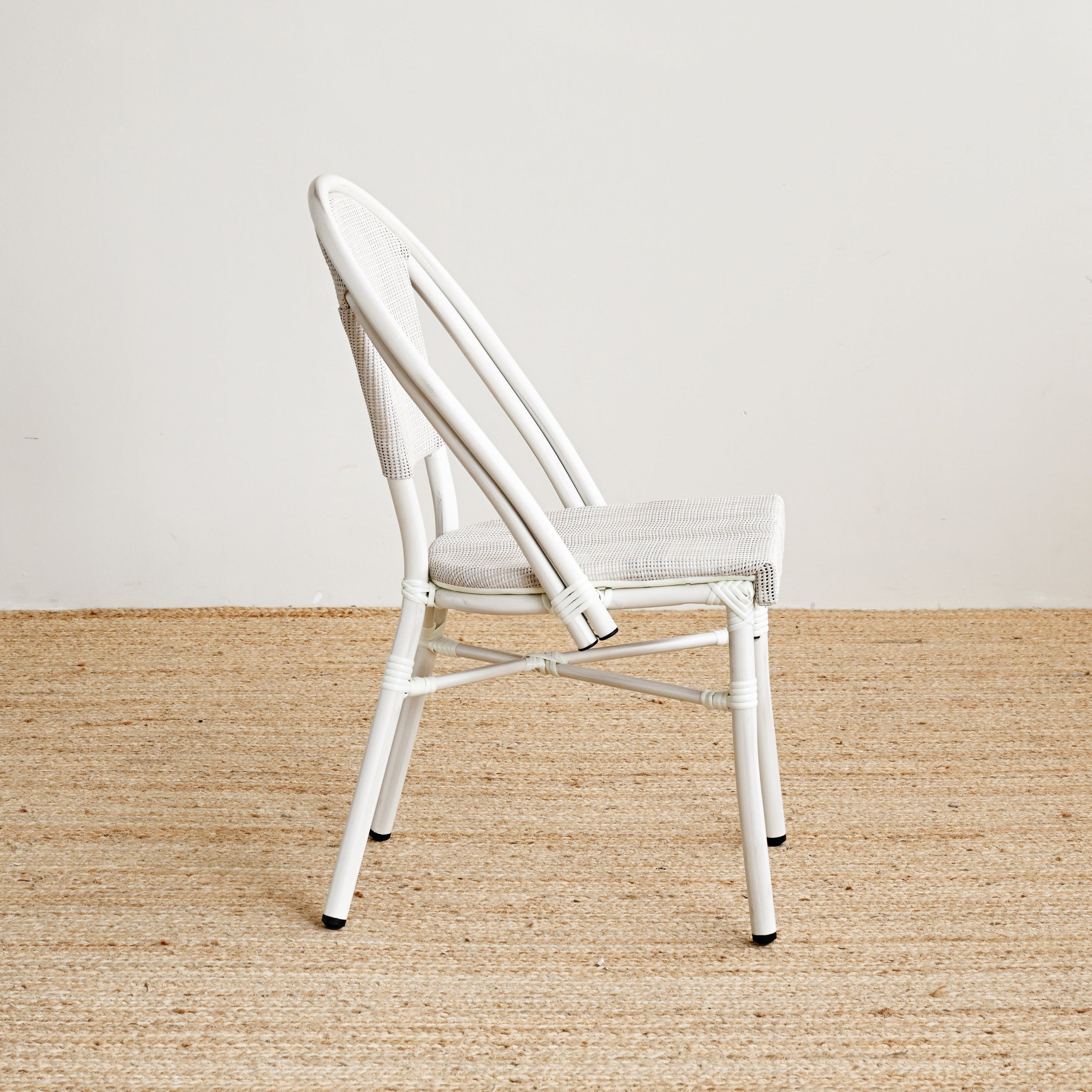 White chair on a beige carpet with a white wall background