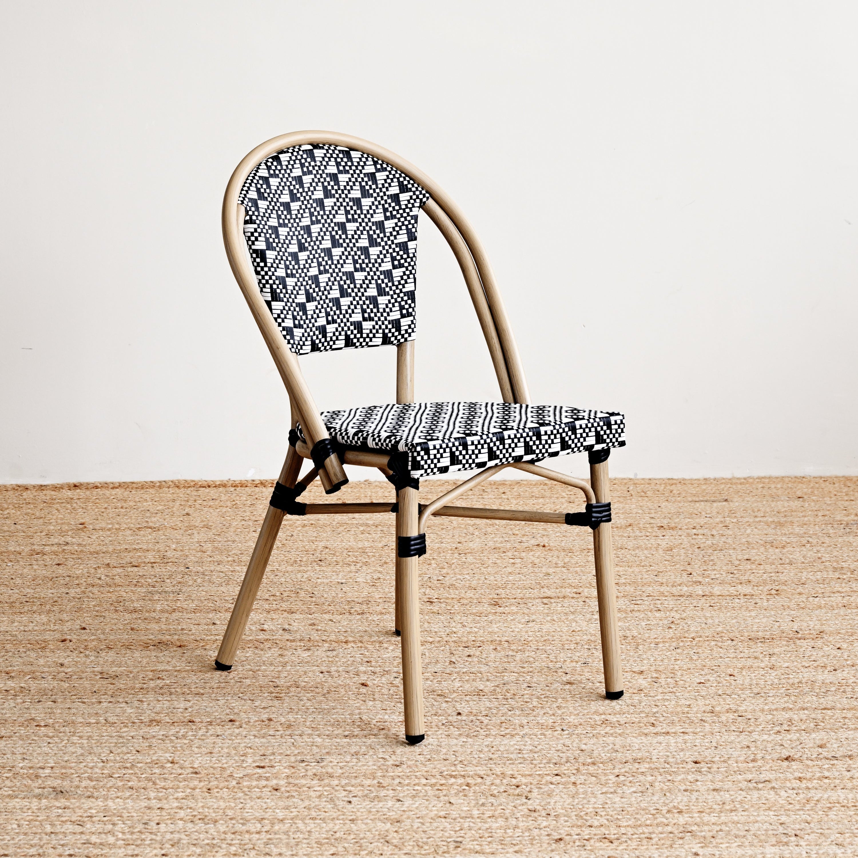 Chair with patterned backrest and seat on a beige floor and white wall background