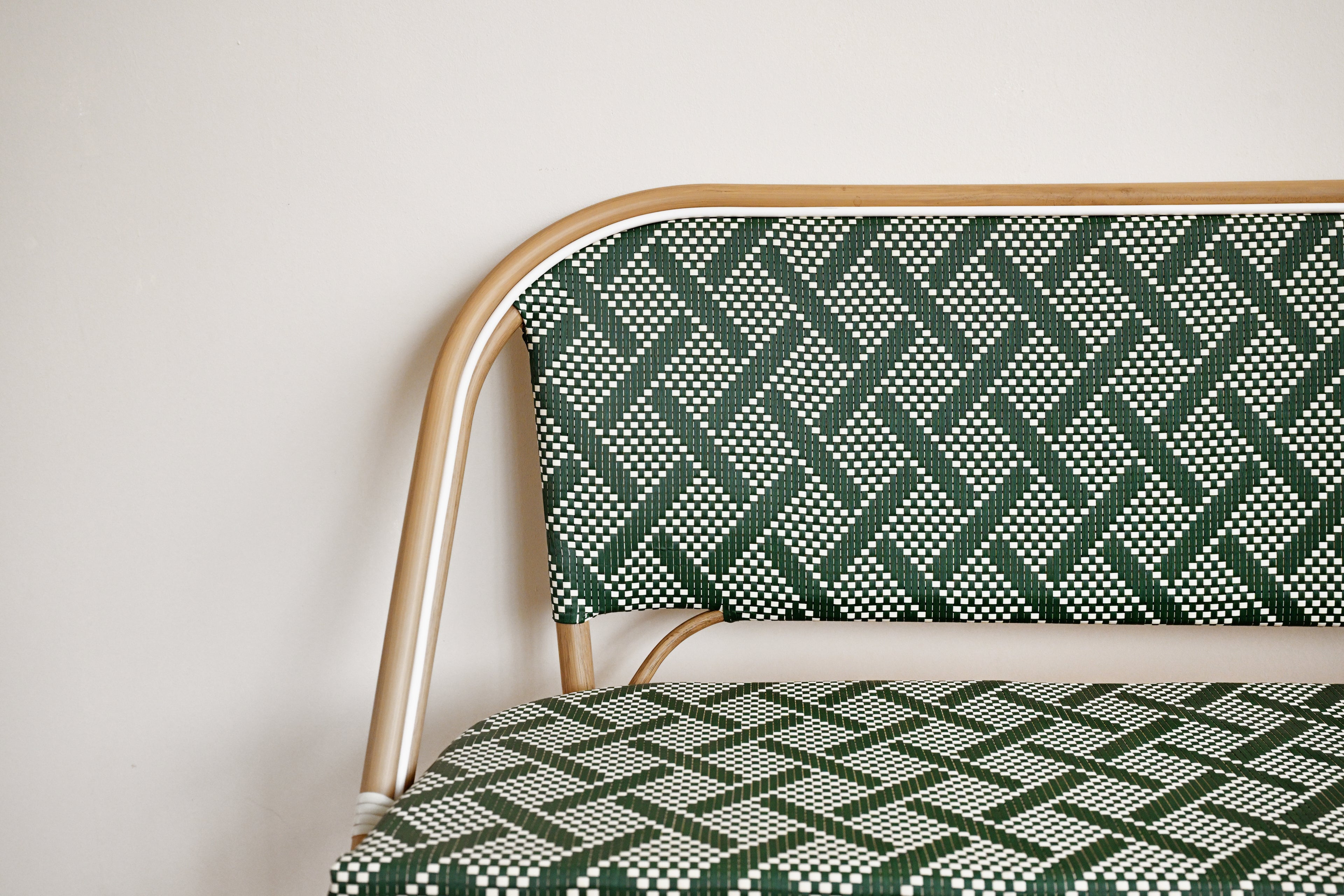 Chair with green and white patterned fabric and gold frame against a plain background