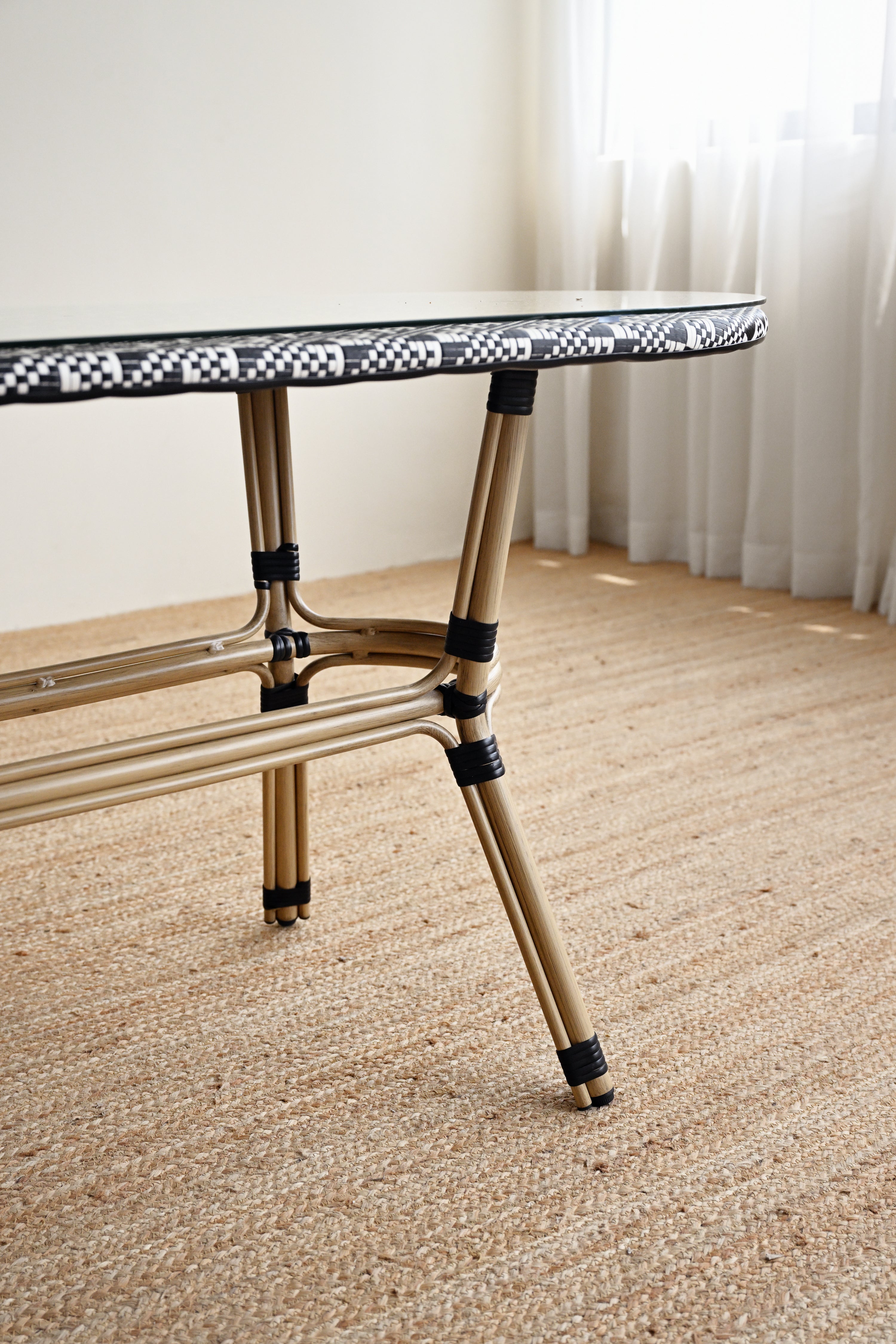 Small round table with a checkered top on a carpeted floor.