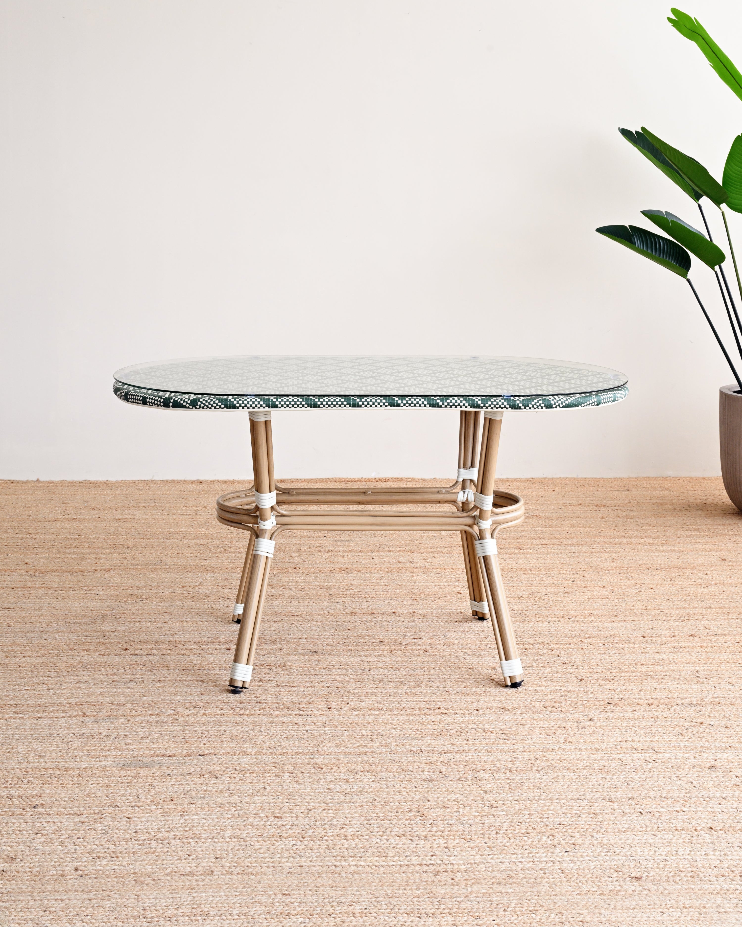 Round marble table with gold legs on a beige rug, plant in the corner.