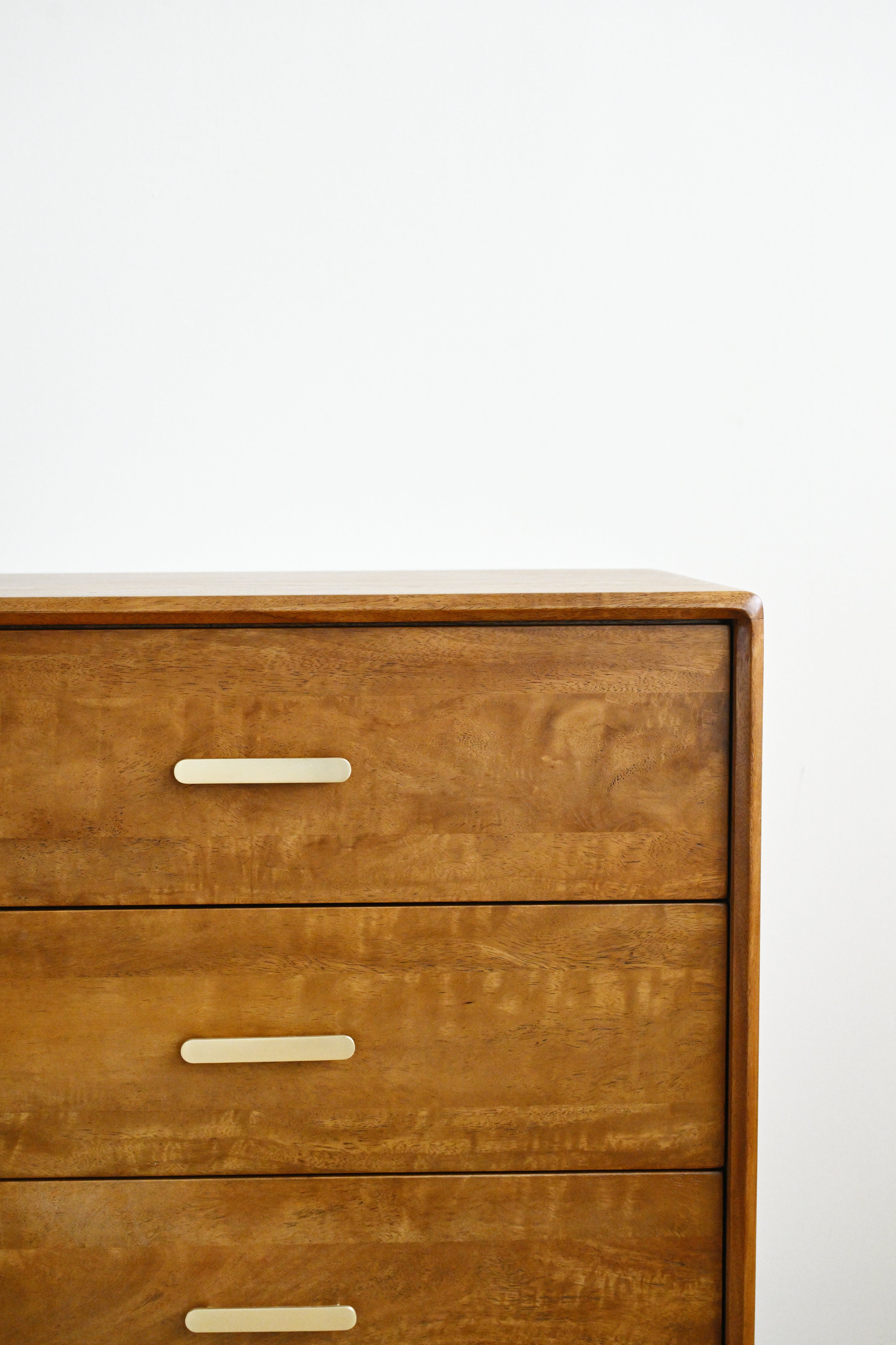 Wooden dresser with three drawers on a white background