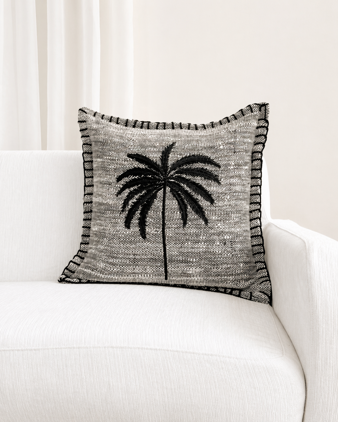 Decorative pillow with palm tree design on a white couch