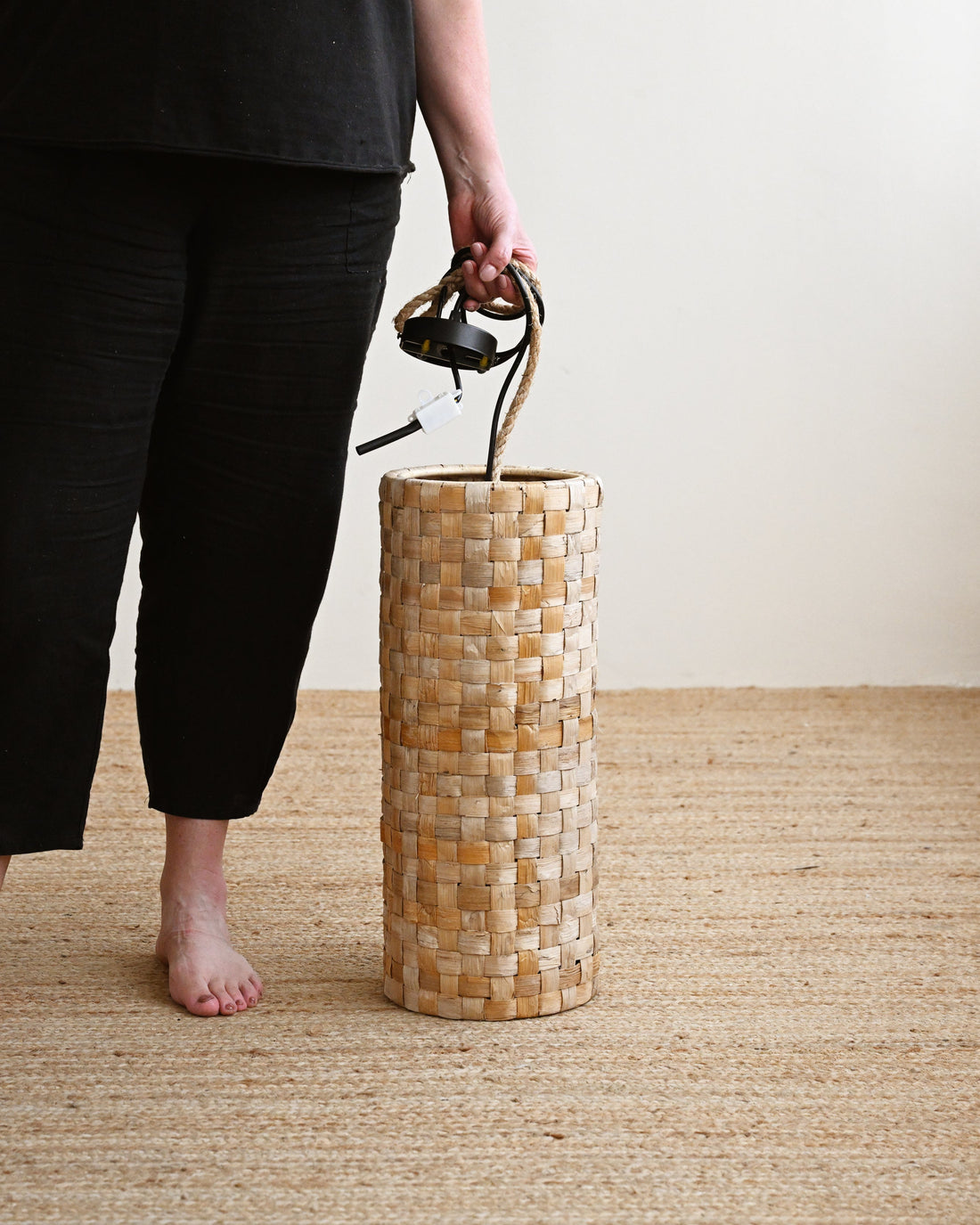Person holding a woven basket with a plain background