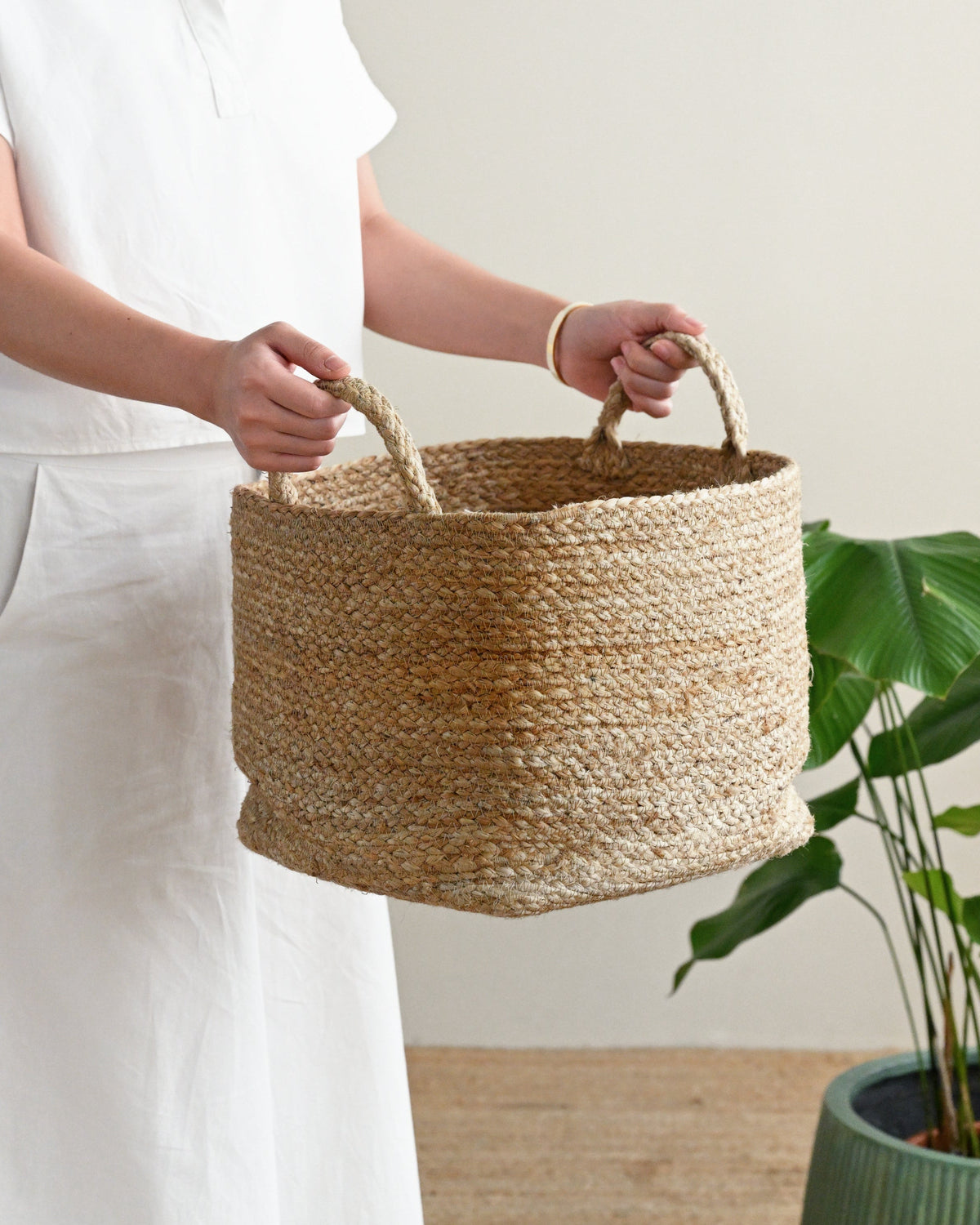 Woman holding a woven basket in a minimalistic indoor setting