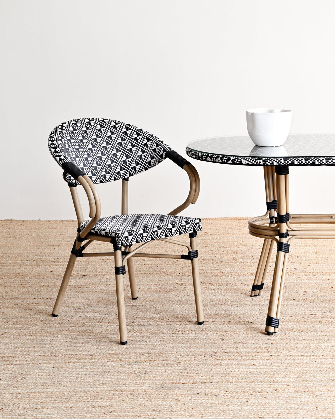 Chair and table with black and white patterned seats and legs on a neutral background
