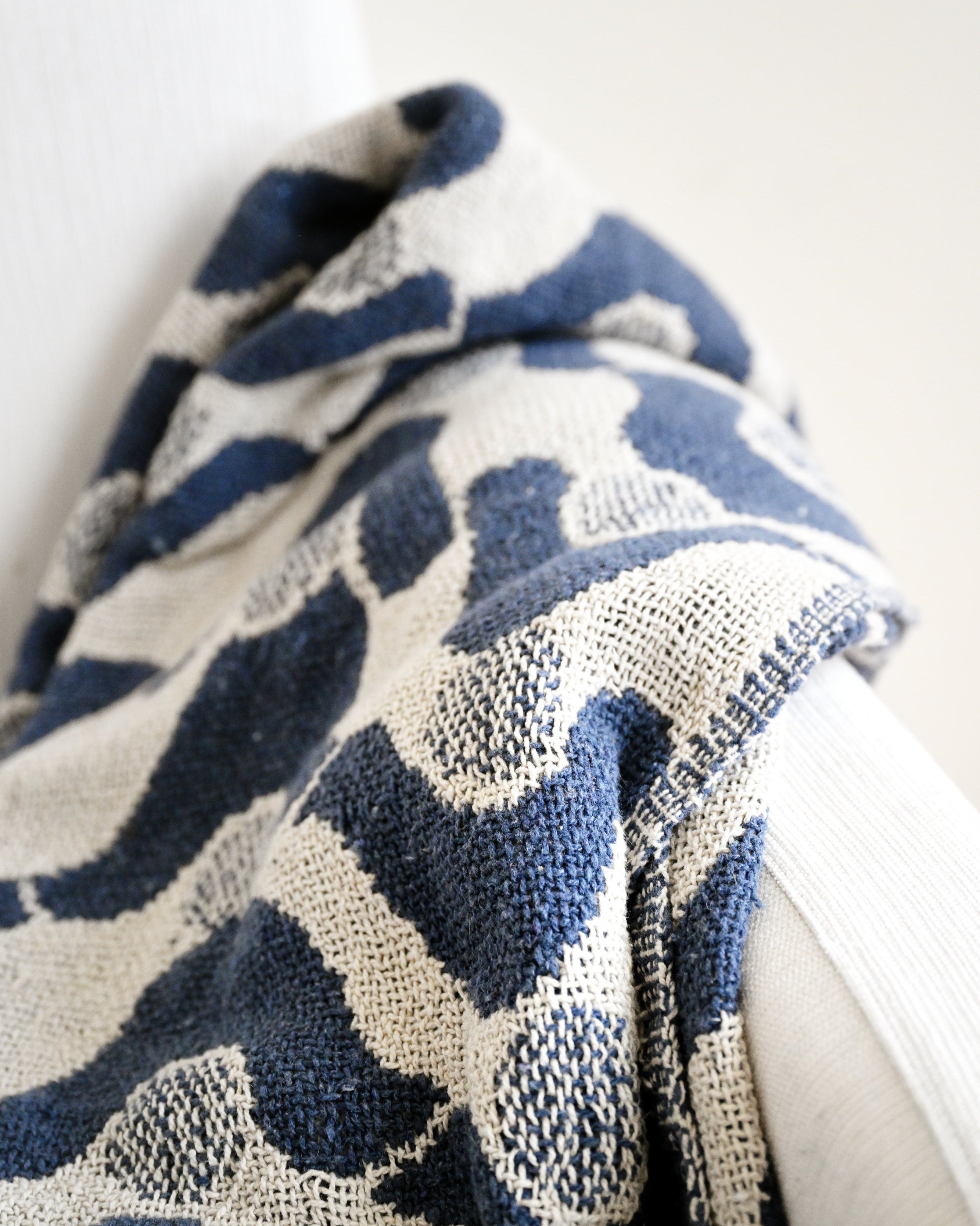 Blue and white patterned fabric draped over a white surface