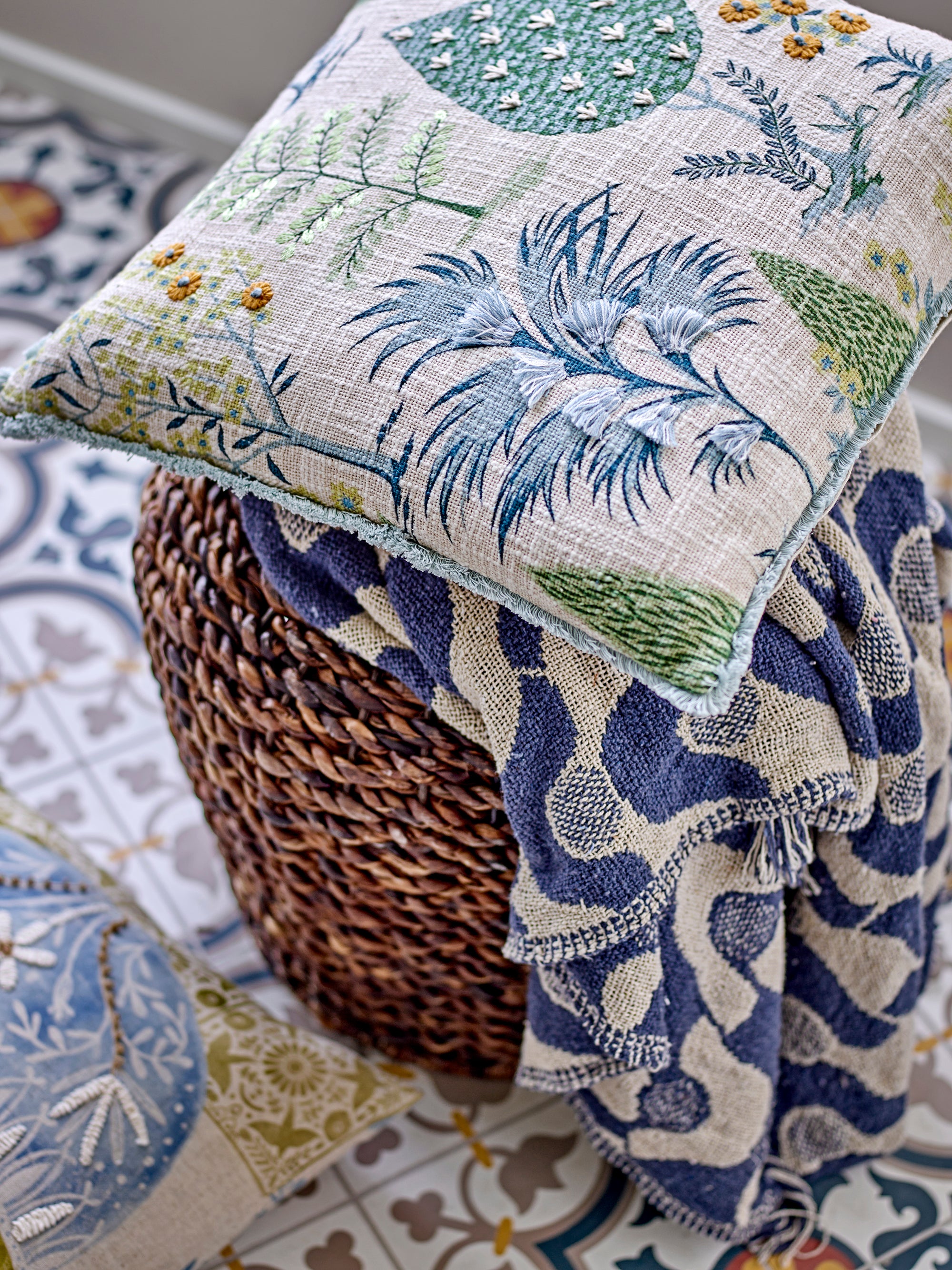 Decorative pillow and blanket with floral patterns on a textured surface