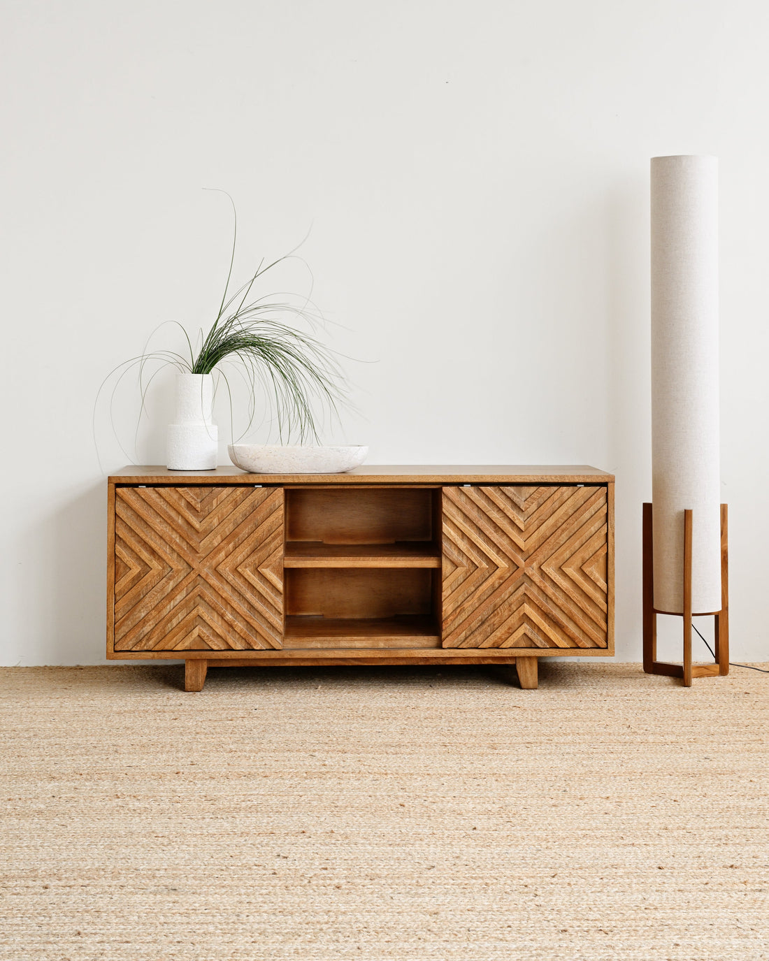 Wooden cabinet with decorative patterns in a minimalistic room.